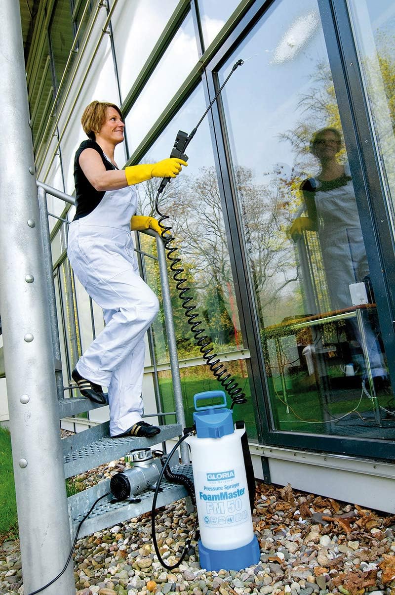 Woman applying foam to a large window with GLORIA FoamMaster FM50