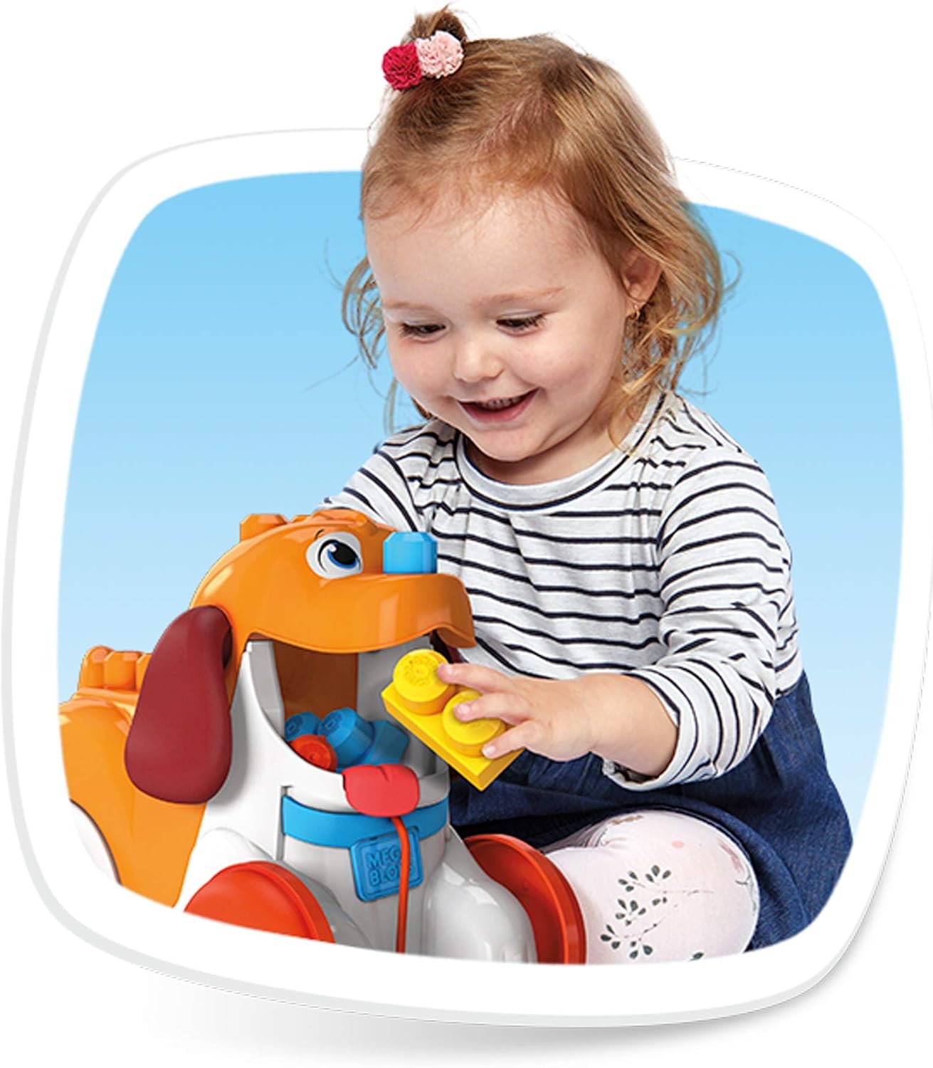 A young child smiling while pulling the Mega Bloks Puppy along a floor.