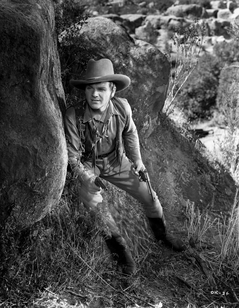 James Cagney Sneaking Behind a Big Rock in Long Sleeve Shirt and Cowboy Hat with Pistol on Hand Photo Print (24 x 30)