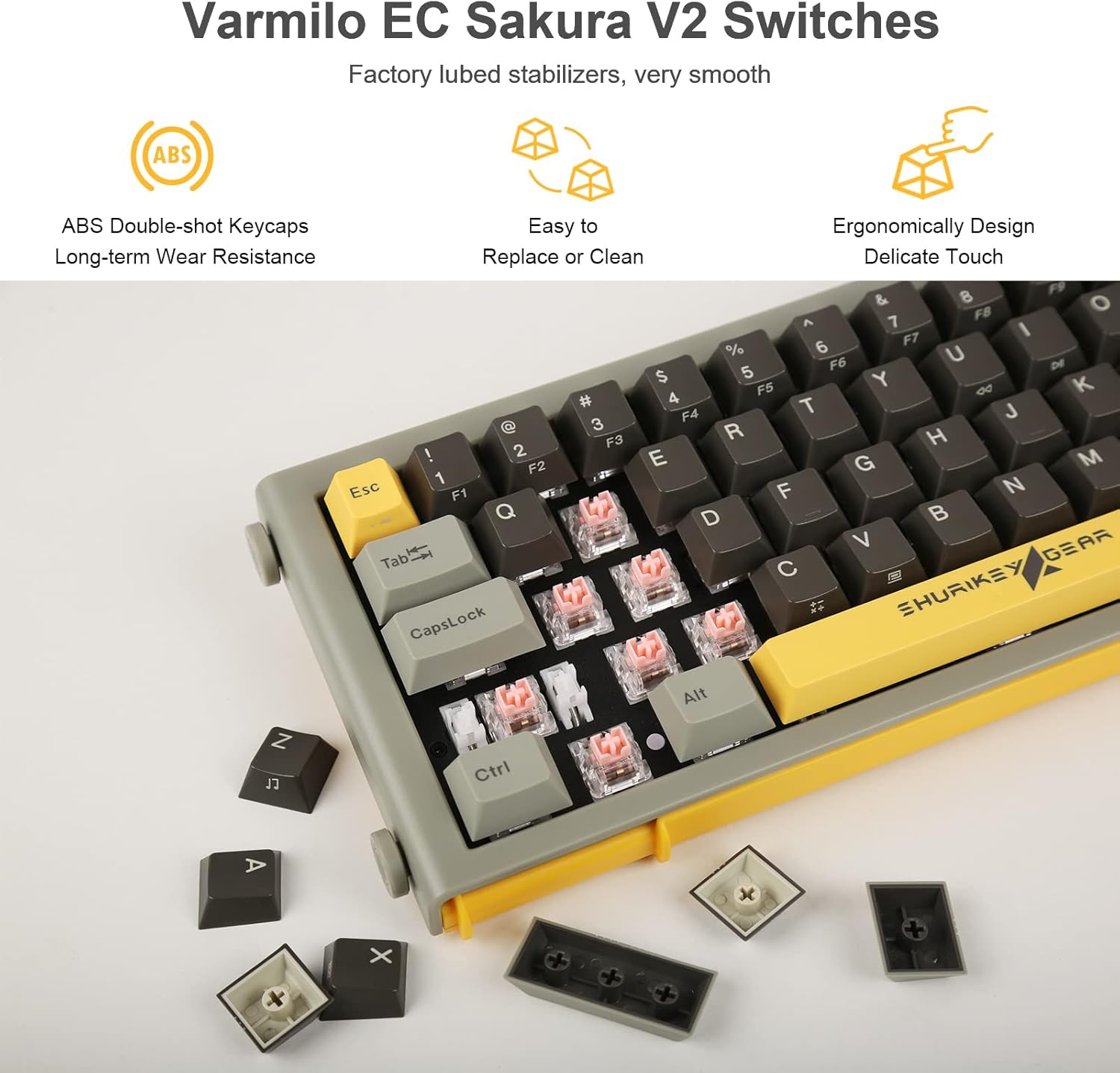 Close-up of the keyboard showing several keycaps removed, revealing the Varmilo EC Sakura V2 switches underneath. Text highlights ABS double-shot keycaps, easy replacement, and ergonomic design.