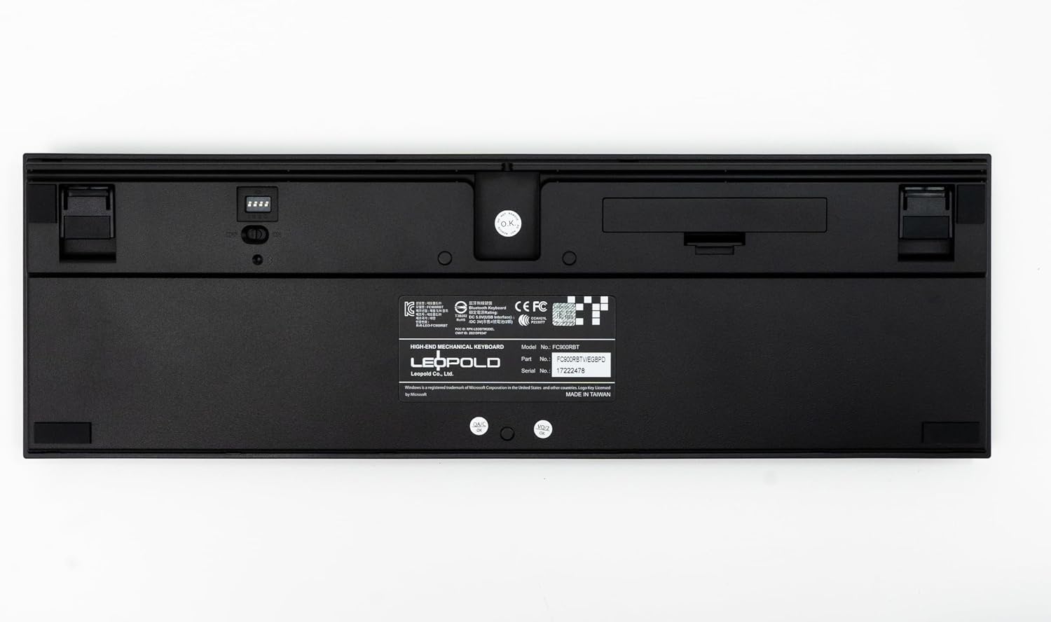 Bas view of the Leopold FC900RBT V2 keyboard, showing the battery compartment and DIP switches.