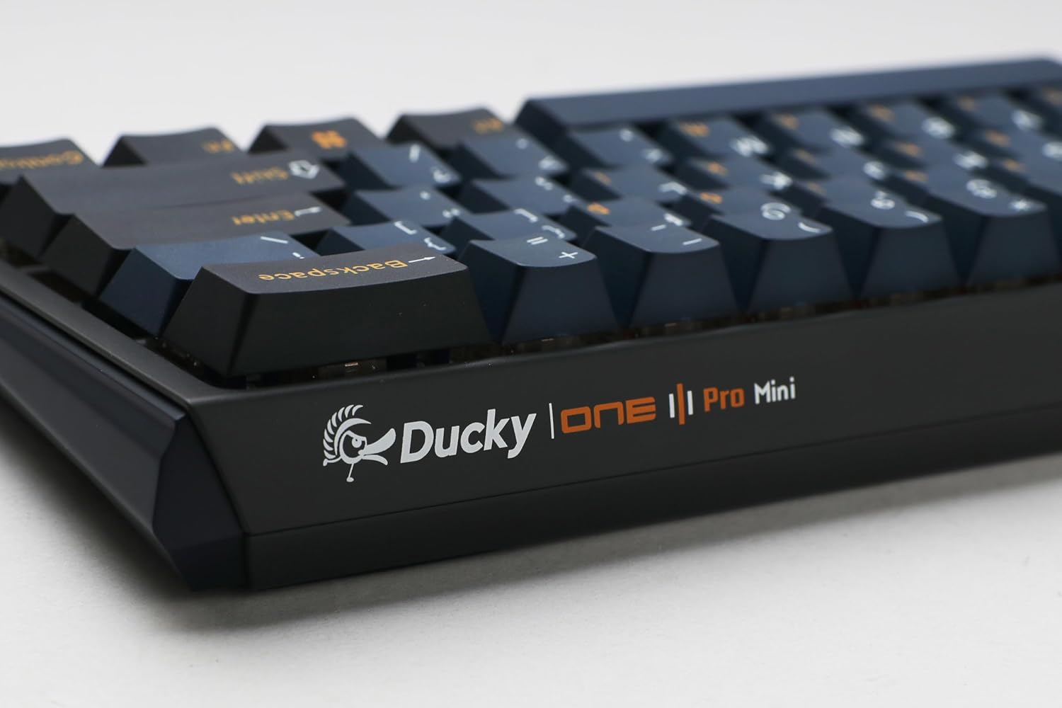 Two removed mechanical switches and keycaps next to the keyboard