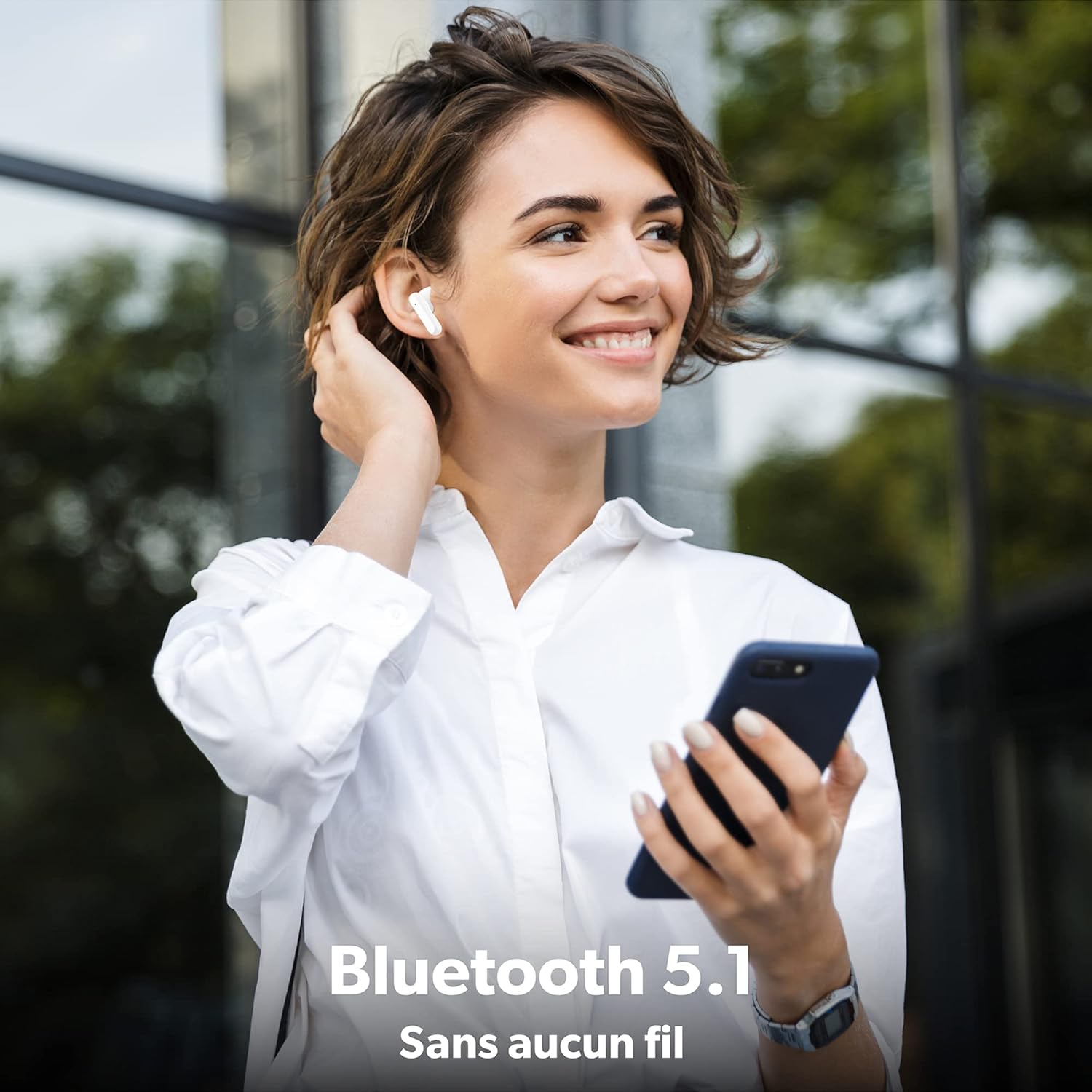 Woman wearing T'NB SHINY2 earbud, holding smartphone