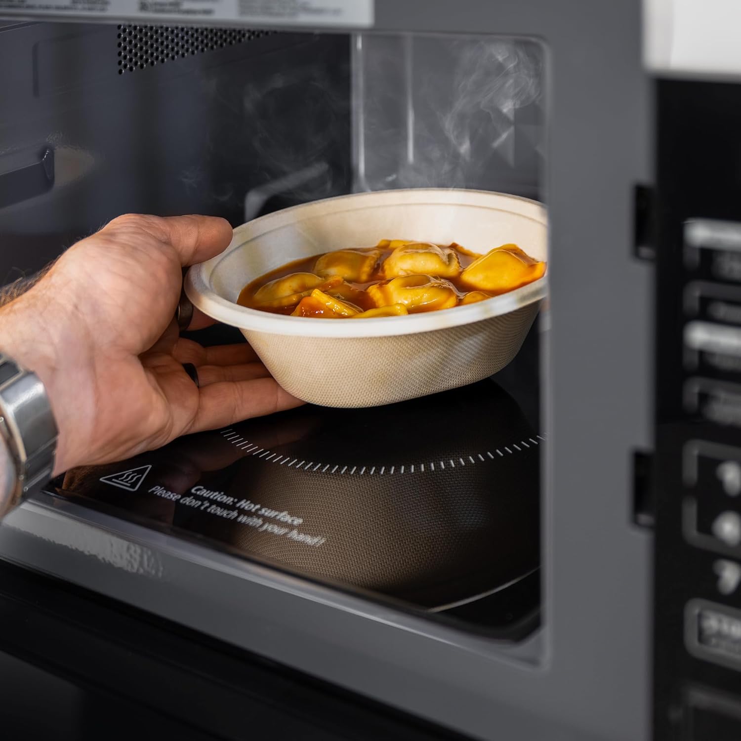 Hand placing food into the RecPro High Pointe Microwave
