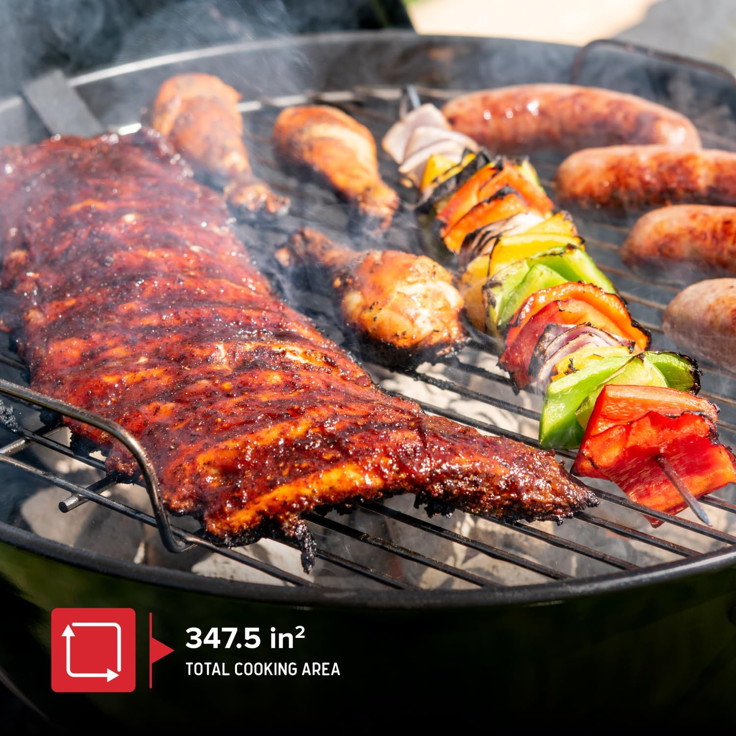 Ġenb view of the grill with food cooking, showing the 347.5 sq. inch cooking area