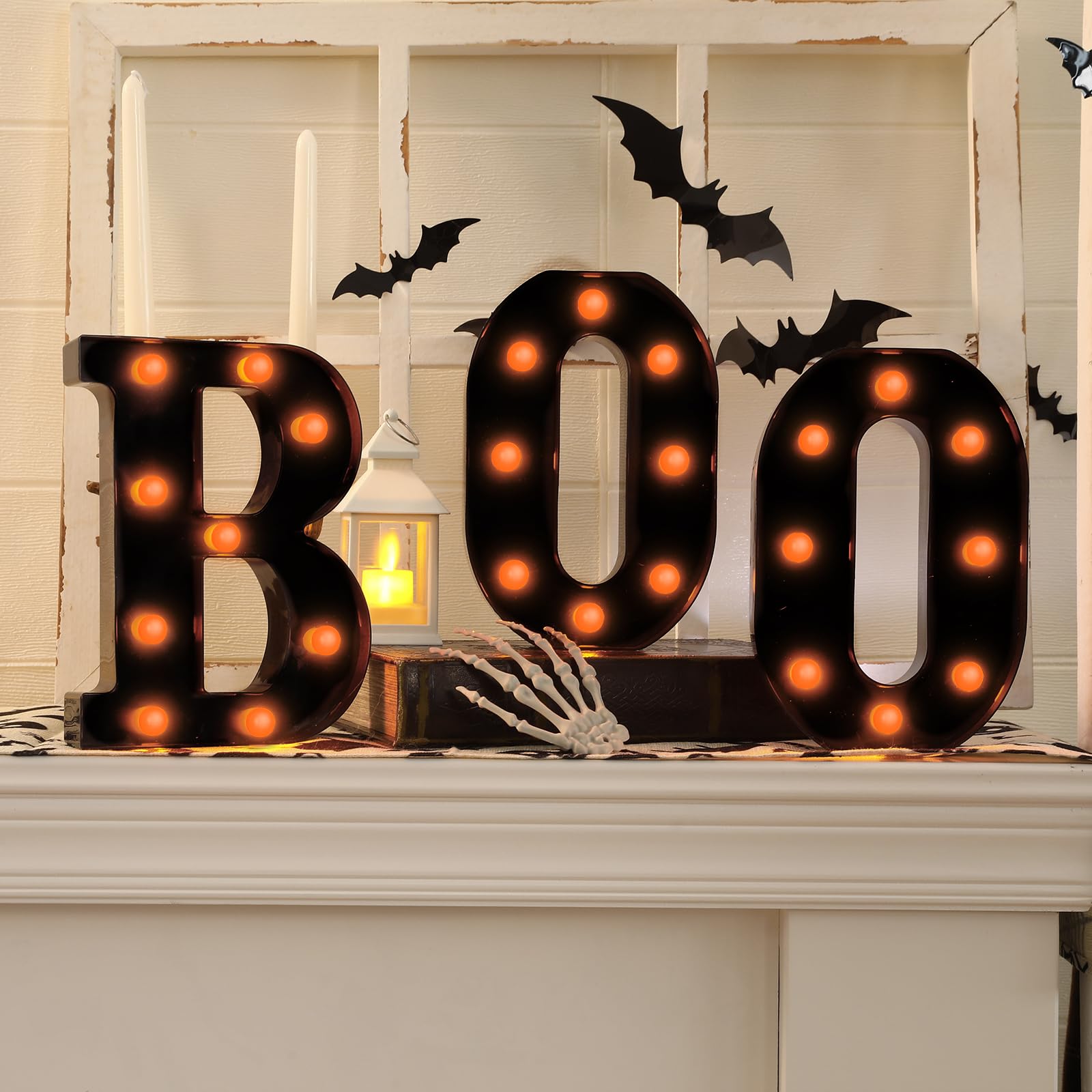 Three black BOO marquee letters with orange bulbs and bat accents