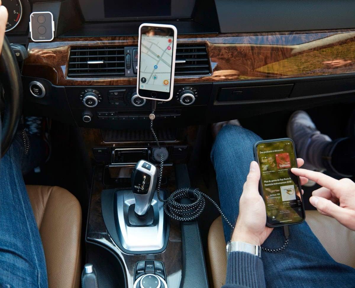 Two phones in a car, one mounted and charging, the other held by hand