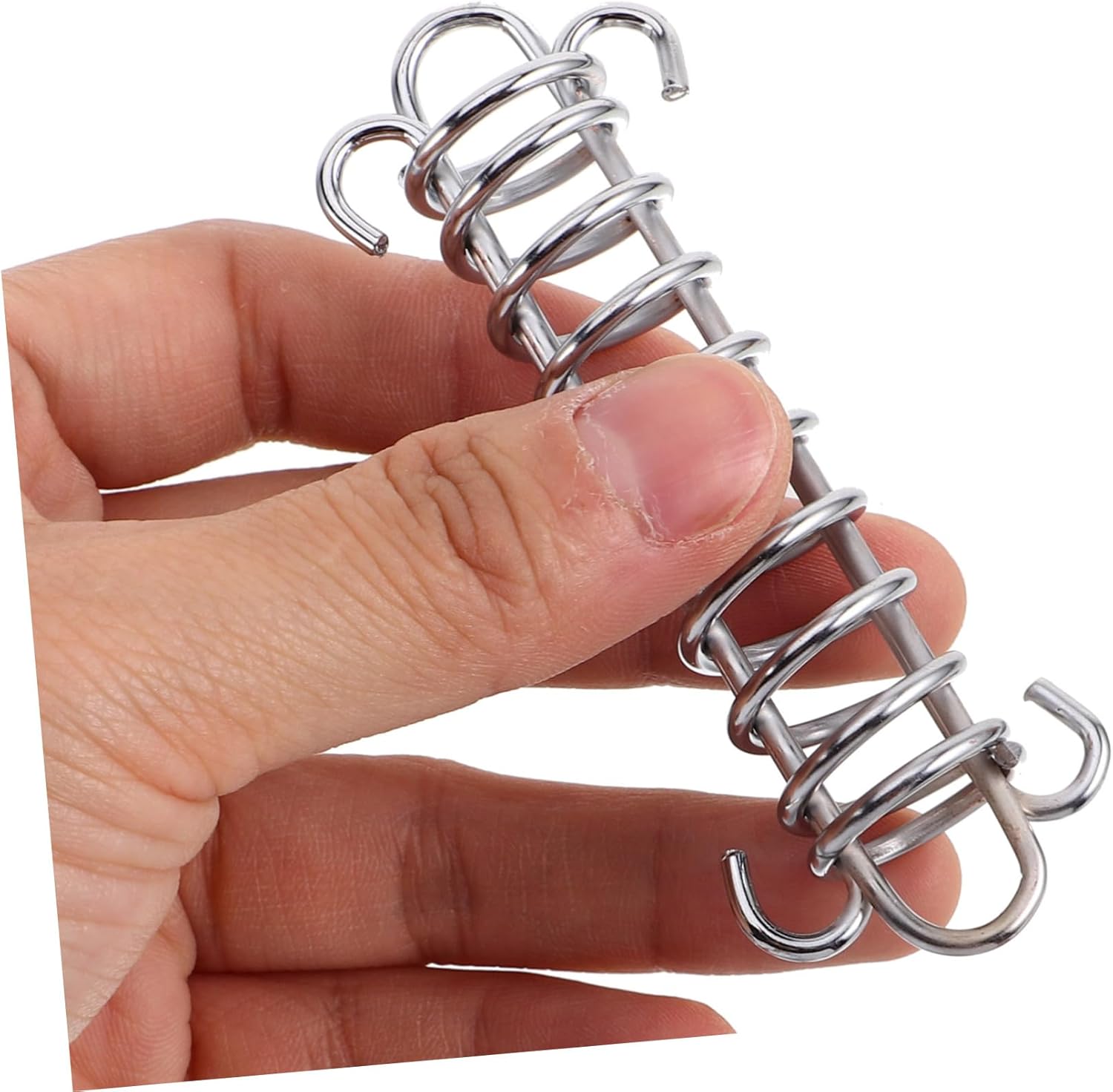 A hand holding a single spring buckle, demonstrating its compact size and ease of handling
