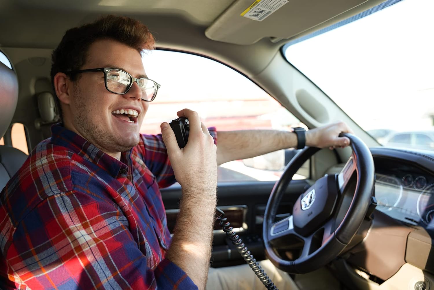 Person operating the AnyTone AT-D578UVIII Plus mobile radio in a vehicle