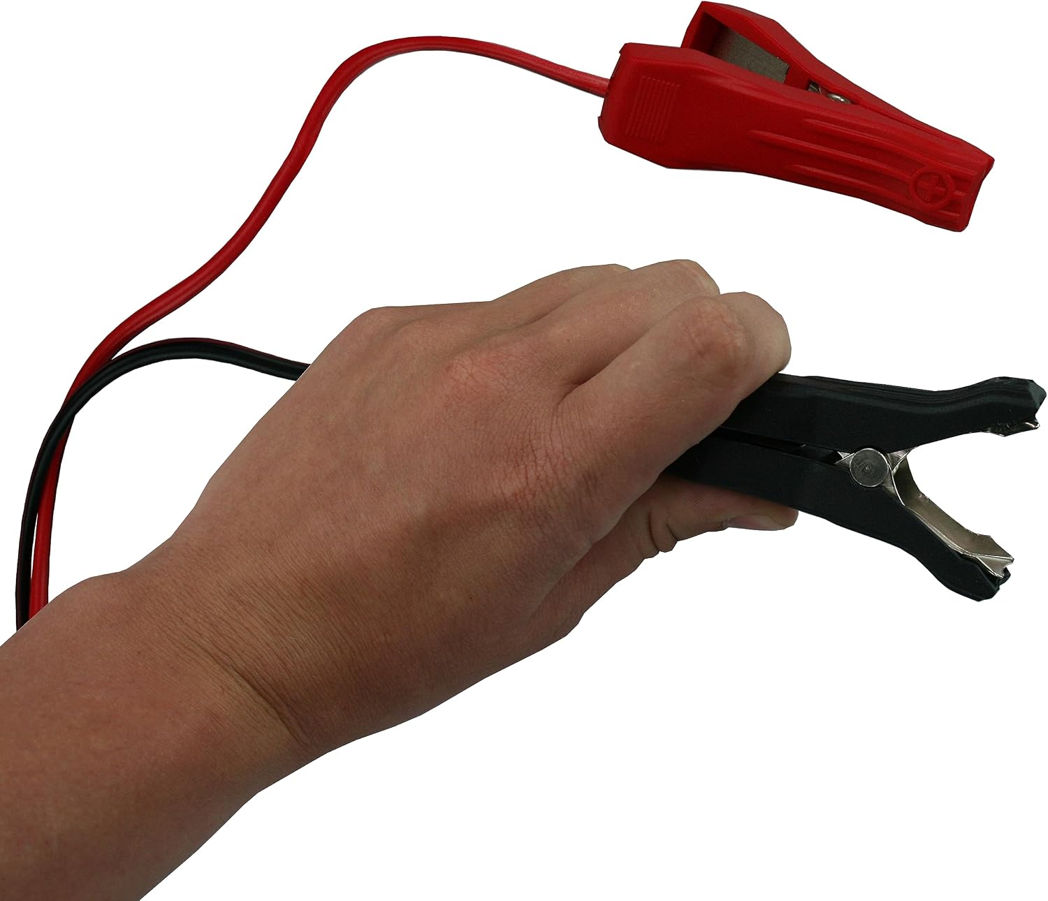 Hand holding red and black alligator clips for battery connection
