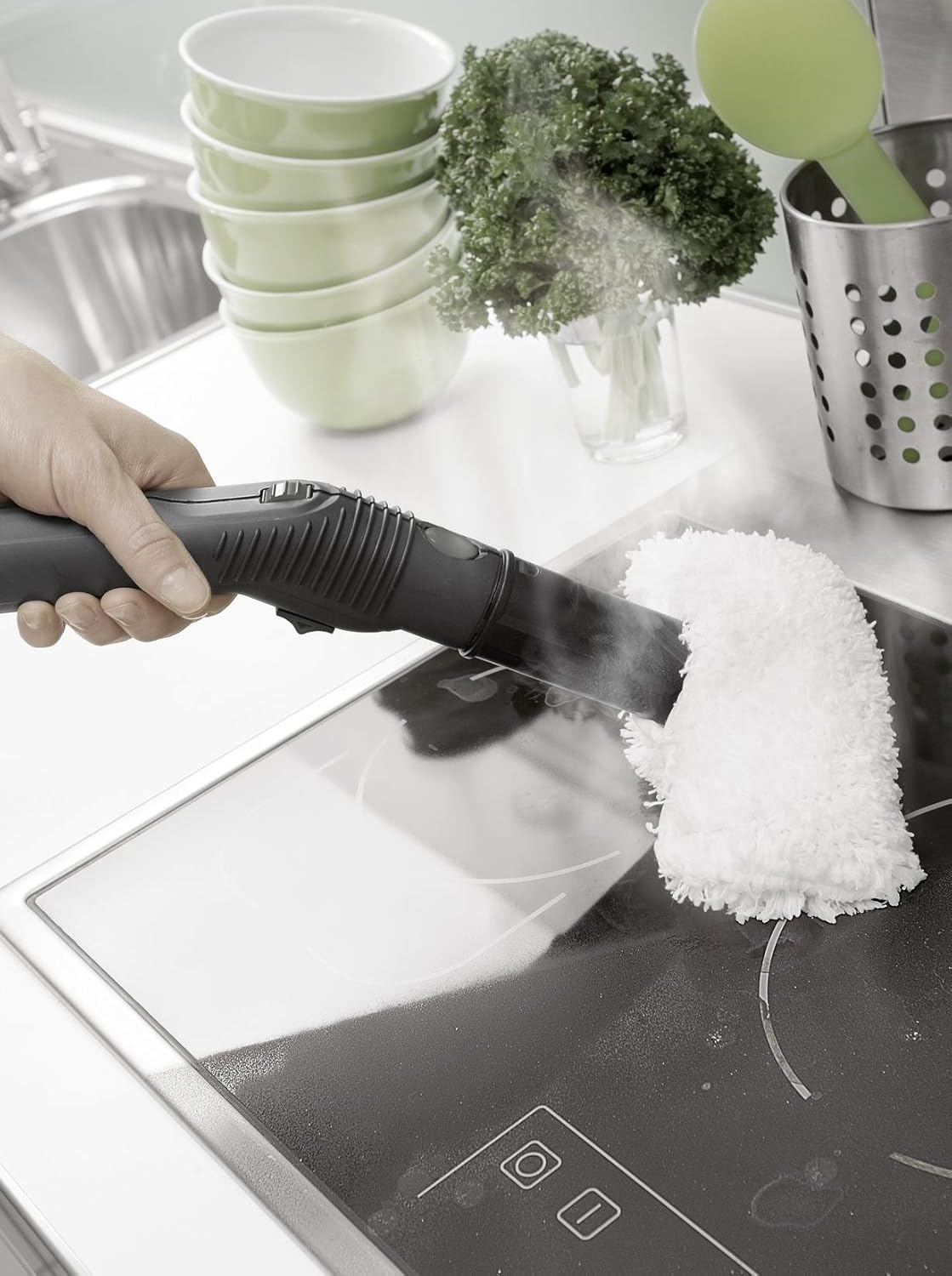 Karcher SC 3000 steam cleaner hand nozzle with cloth cover cleaning a ceramic stovetop in a kitchen.