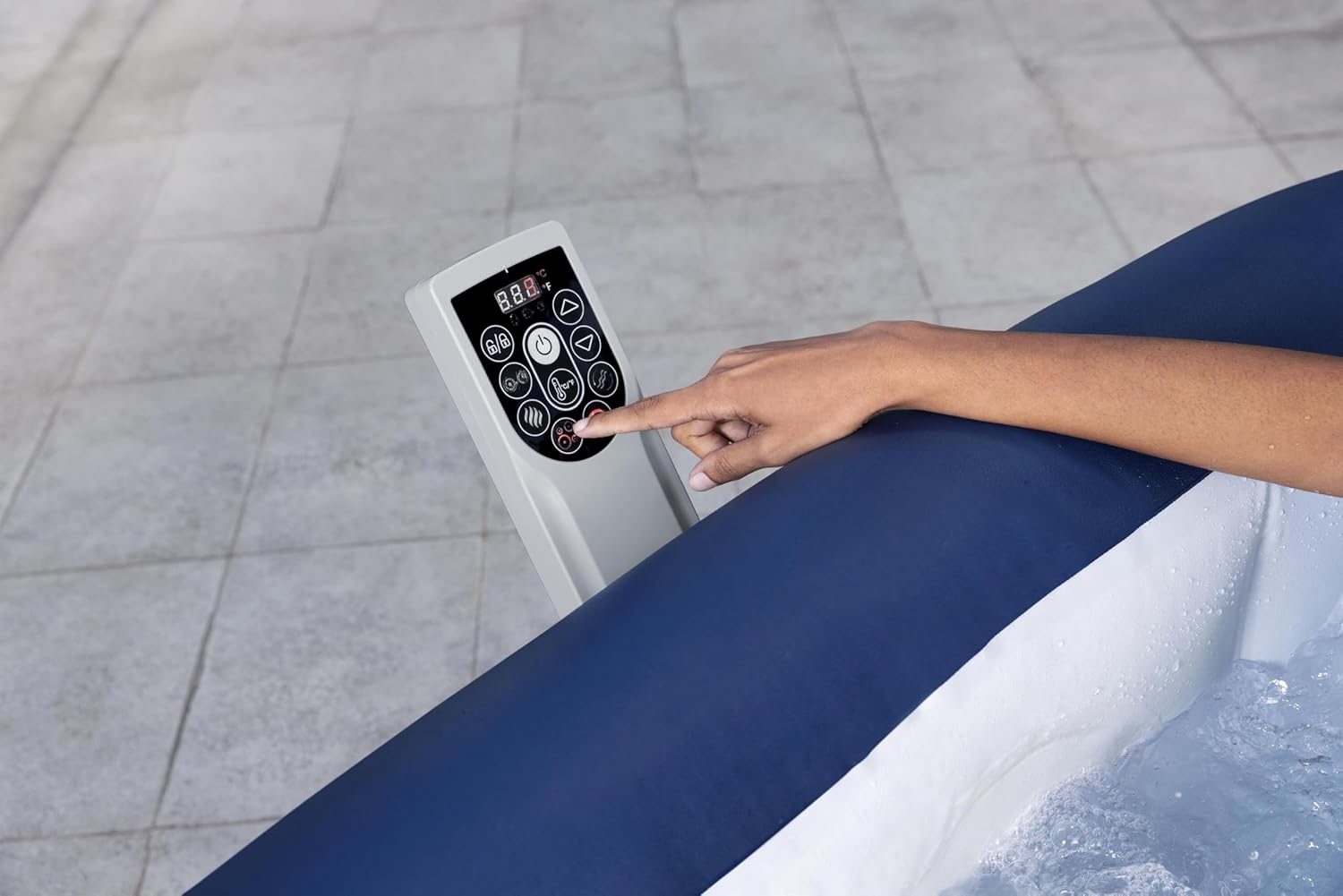Hand operating the digital control panel of the Bestway Lay-Z-Spa