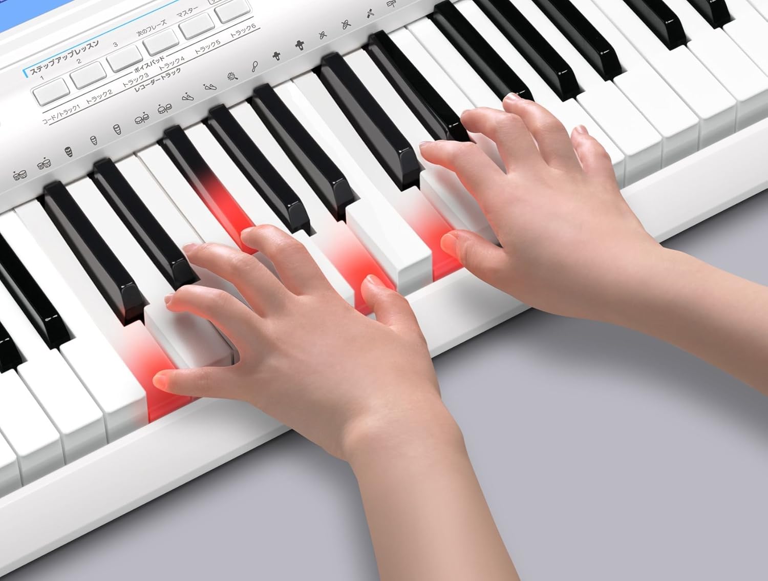 Hands playing on the CASIO LK-208 keyboard with light-up keys guiding the user