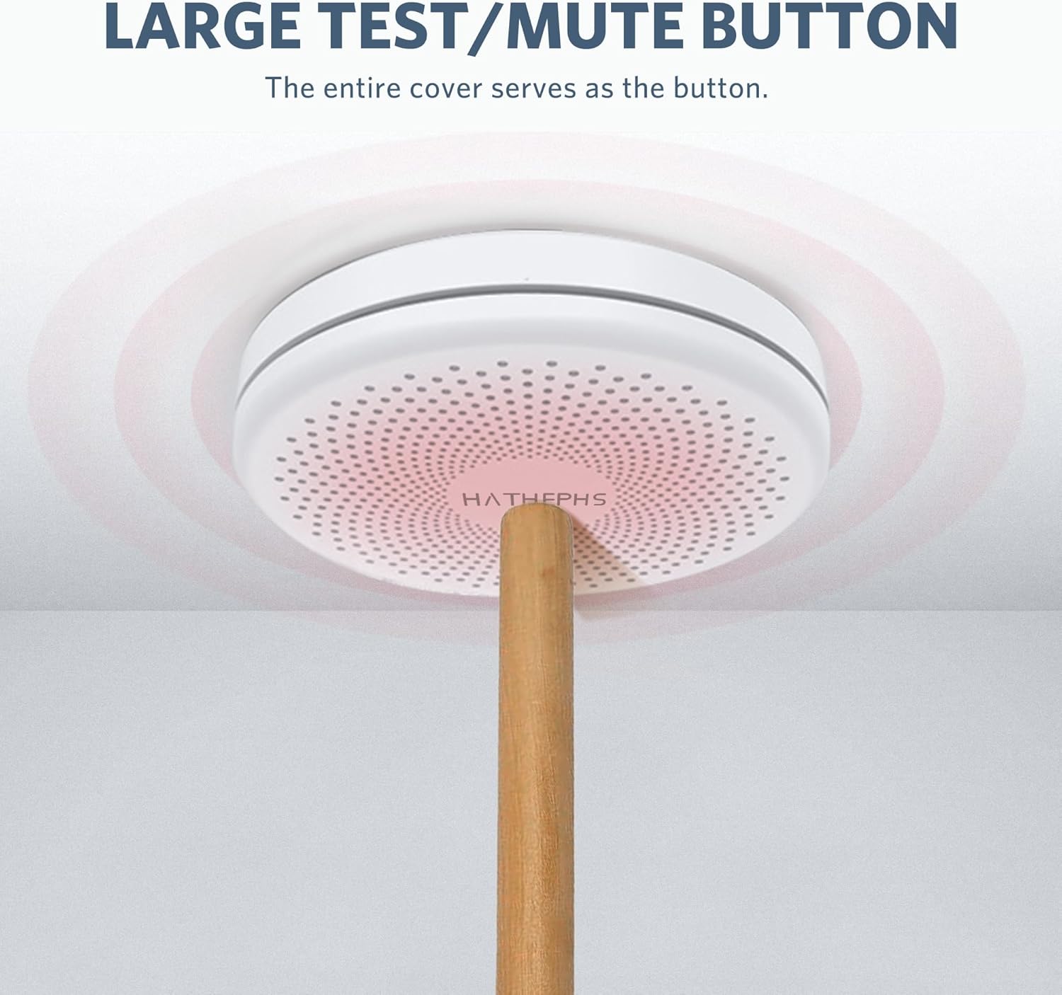 Person using a stick to press the large test/mute button on the detector