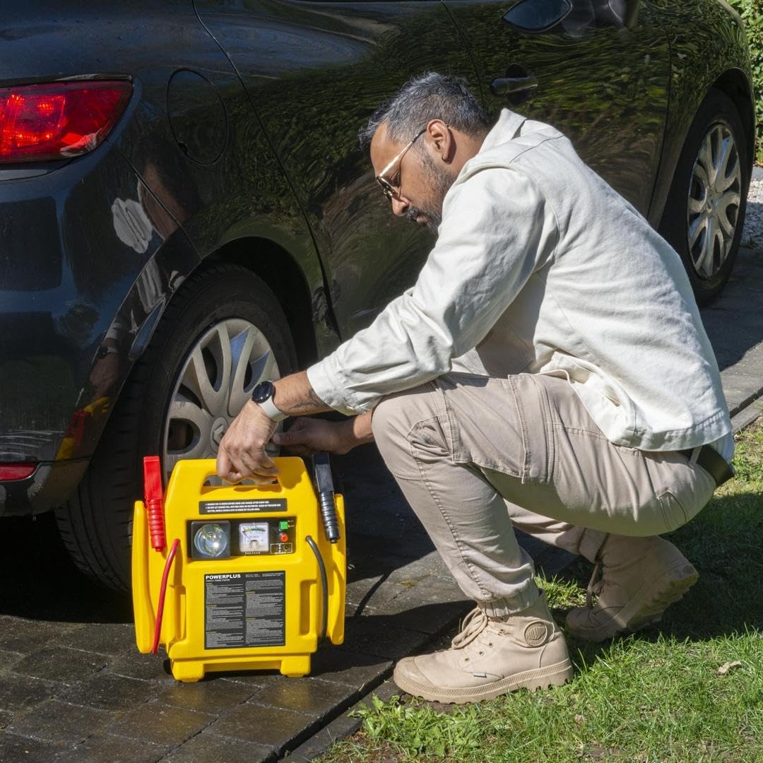 A person using the POWERPLUS Powerstation to inflate a car tire, demonstrating the air compressor function.