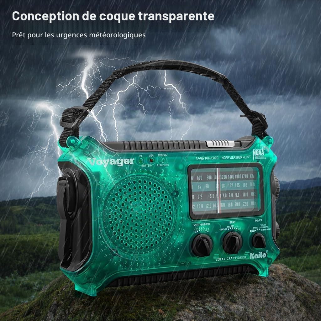 A person operating the hand crank on the Kaito KA500 radio in an outdoor setting.