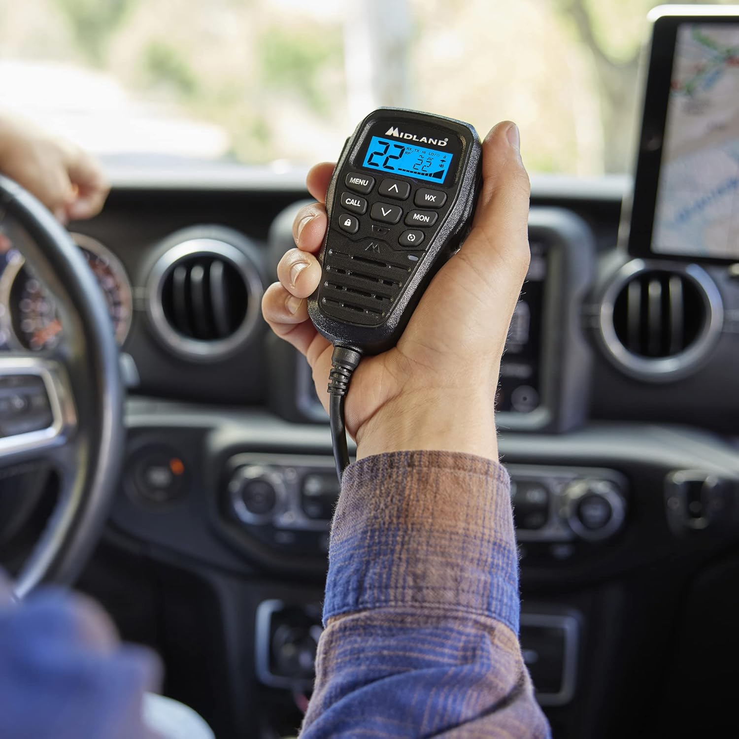 Hand holding Midland MXT275 integrated control microphone in a vehicle