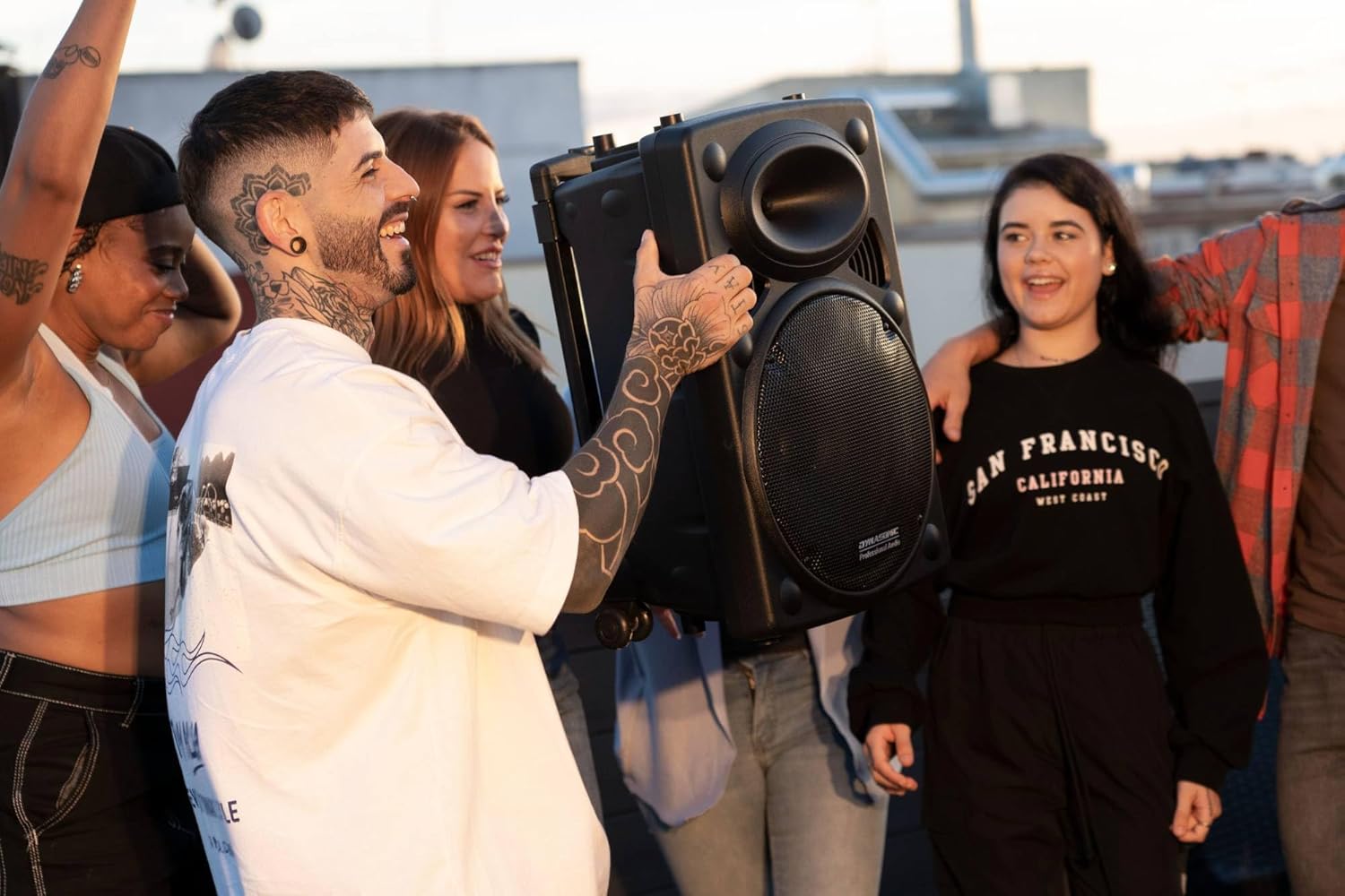 Group of people enjoying music from a DYNASONIC Dynapro 12 speaker in an outdoor setting