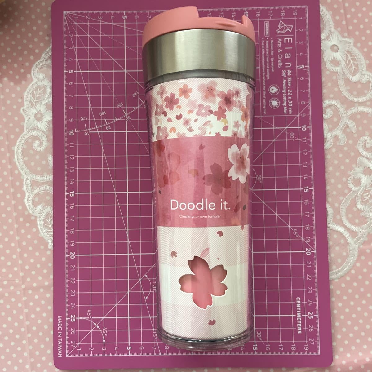 Starbucks tumbler on a measuring mat, showing its approximate dimensions