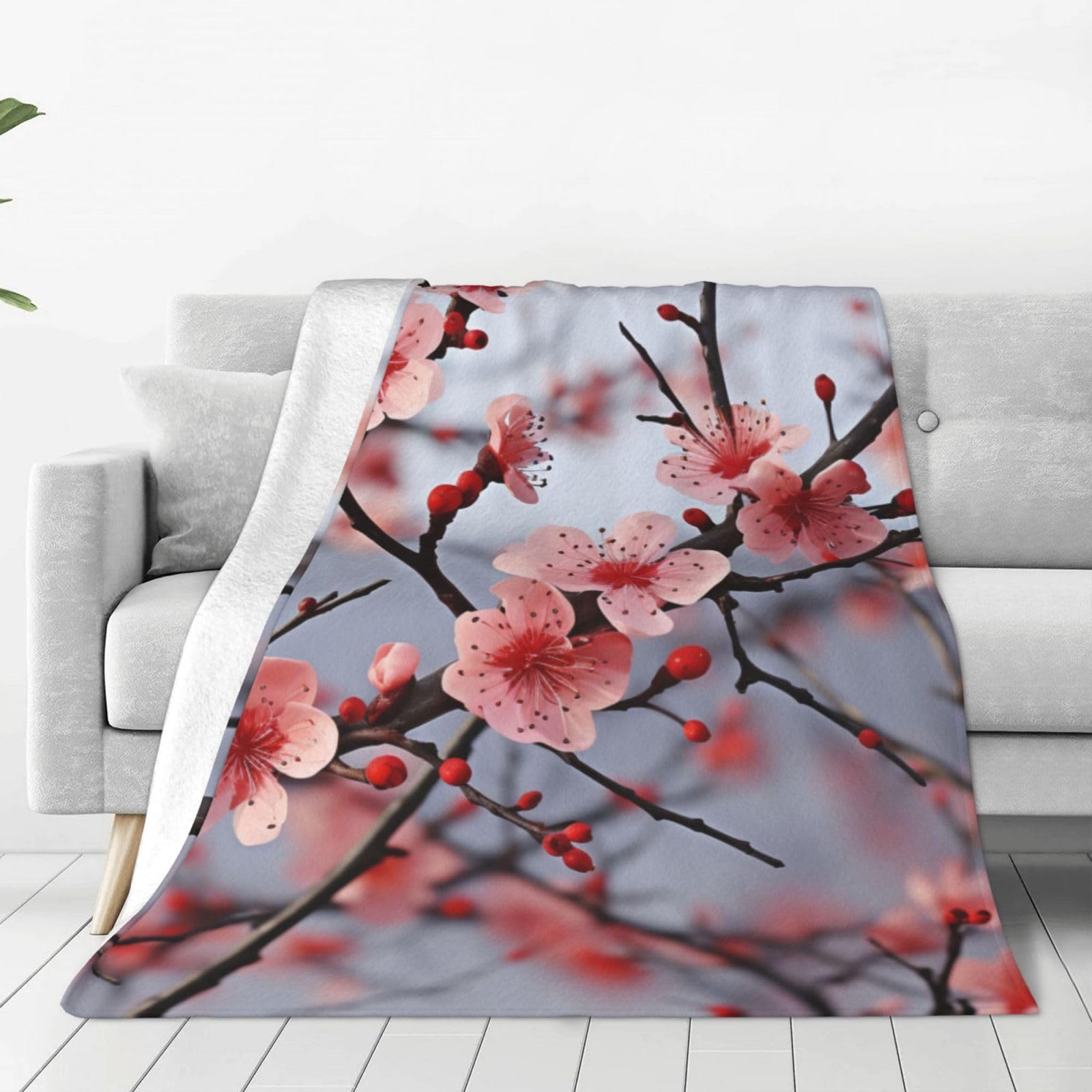 Couverture en fleurs de cerisier pour cocooning sur canapé et fauteuil de salon cosy