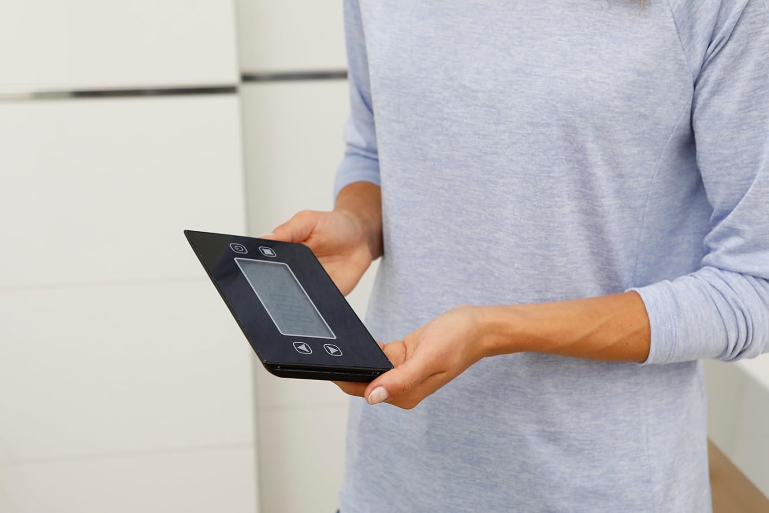 Close-up of a person holding the Medisana BS 460 removable display