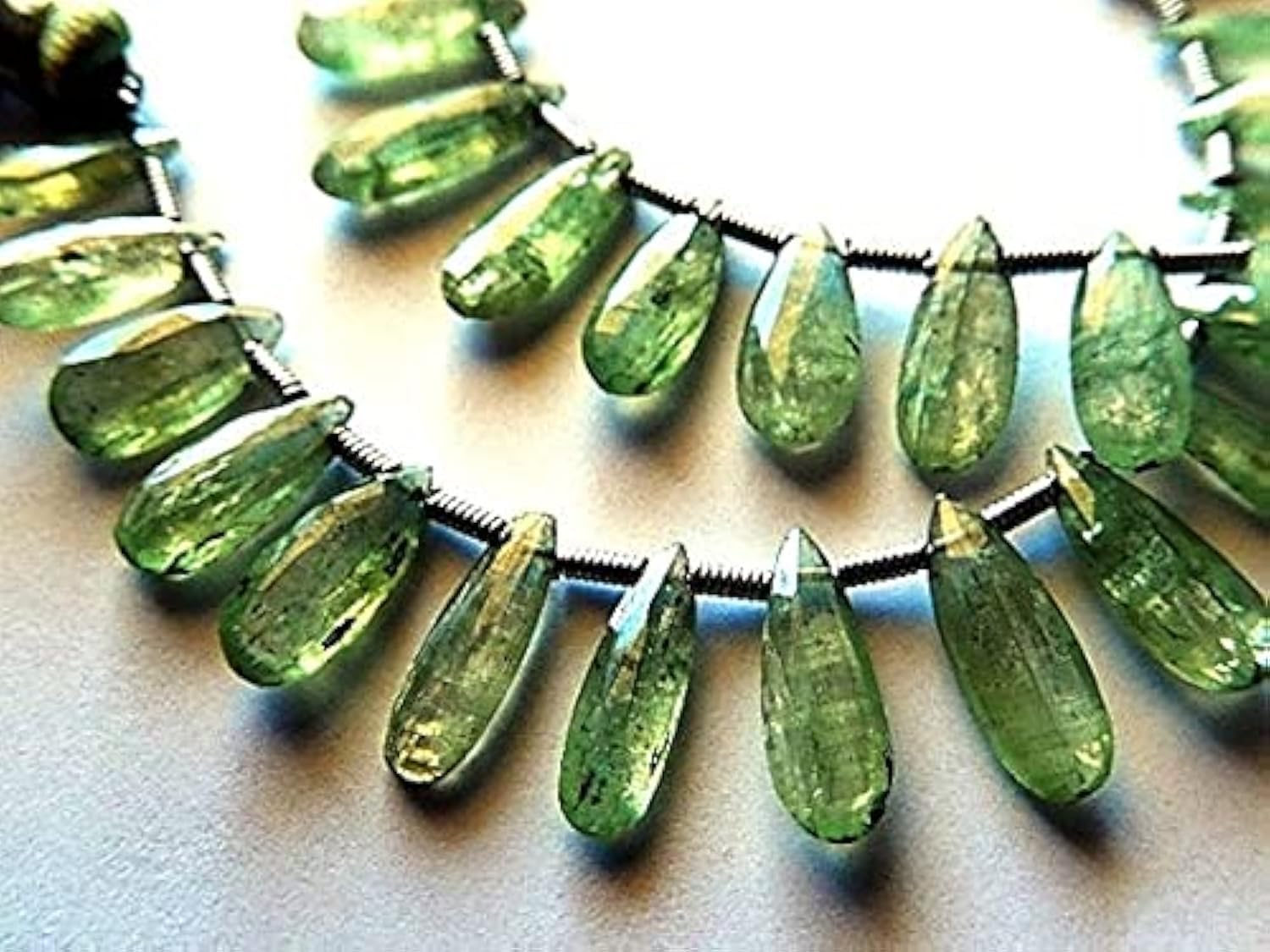 Perle kyanite verte facettée en briolette pour créer un collier d'été bohème chic