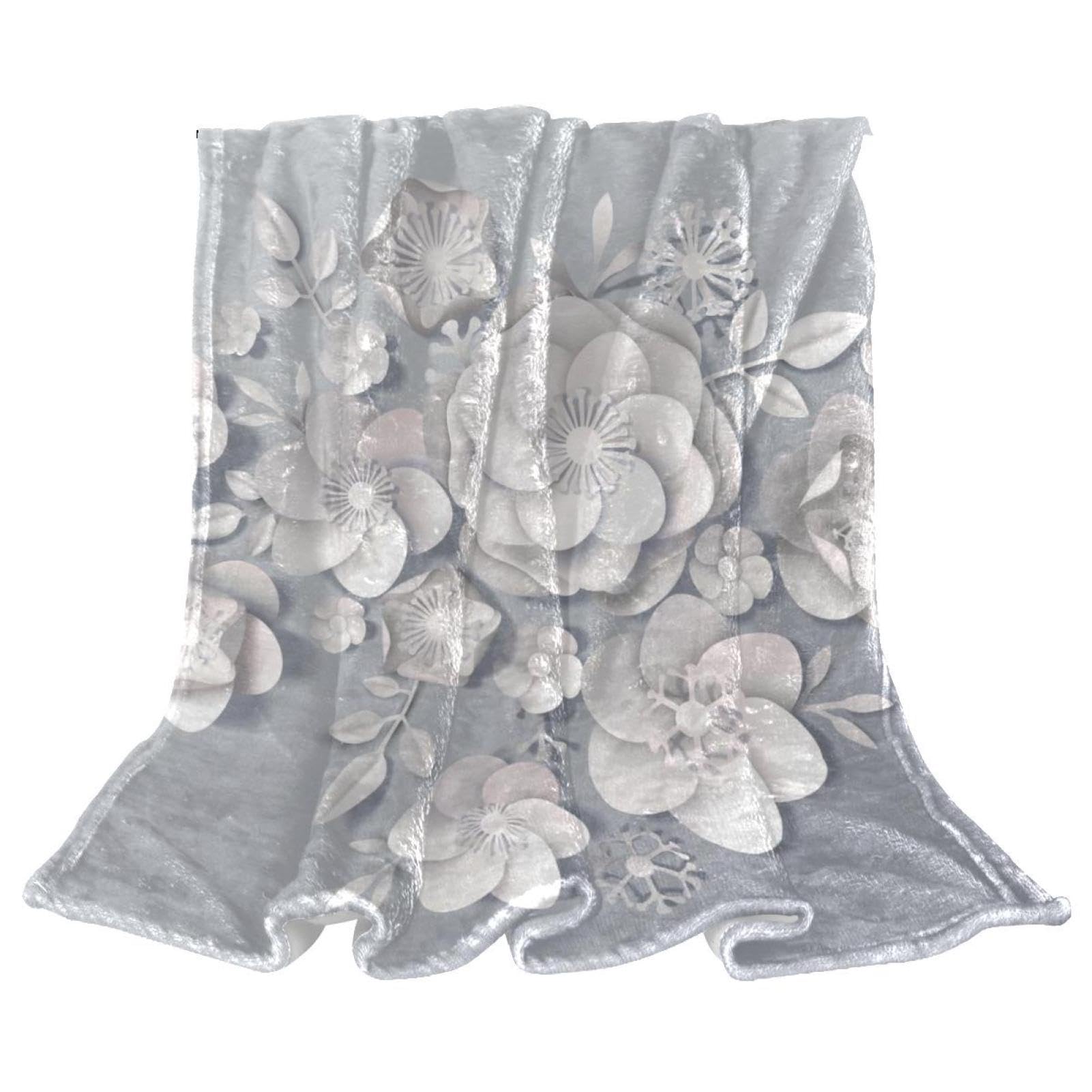 Couverture polaire fleurs blanches idéale pour vos soirées sur le canapé