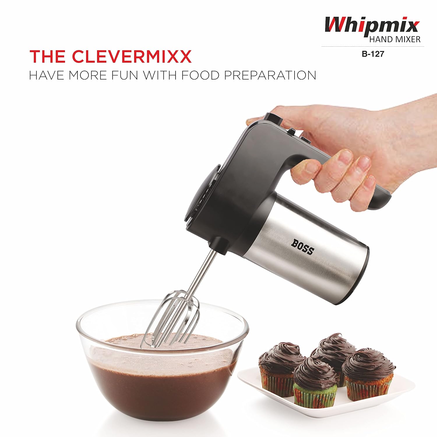Hand holding the BOSS Whipmix Hand Mixer with beater attachments mixing batter in a glass bowl.