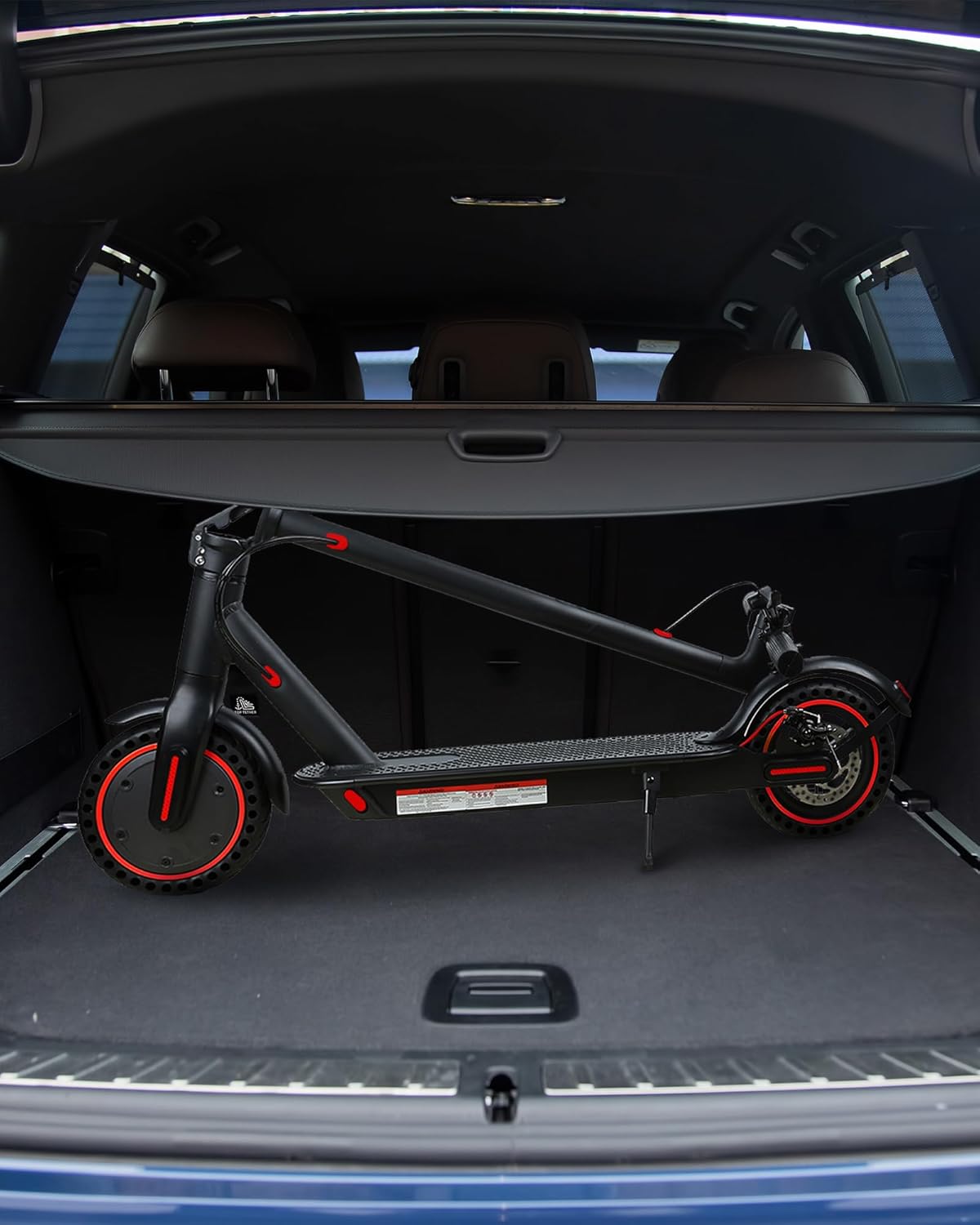 Image of the QnQ H8501 Electric Scooter folded and placed in the trunk of a car, demonstrating its portability.
