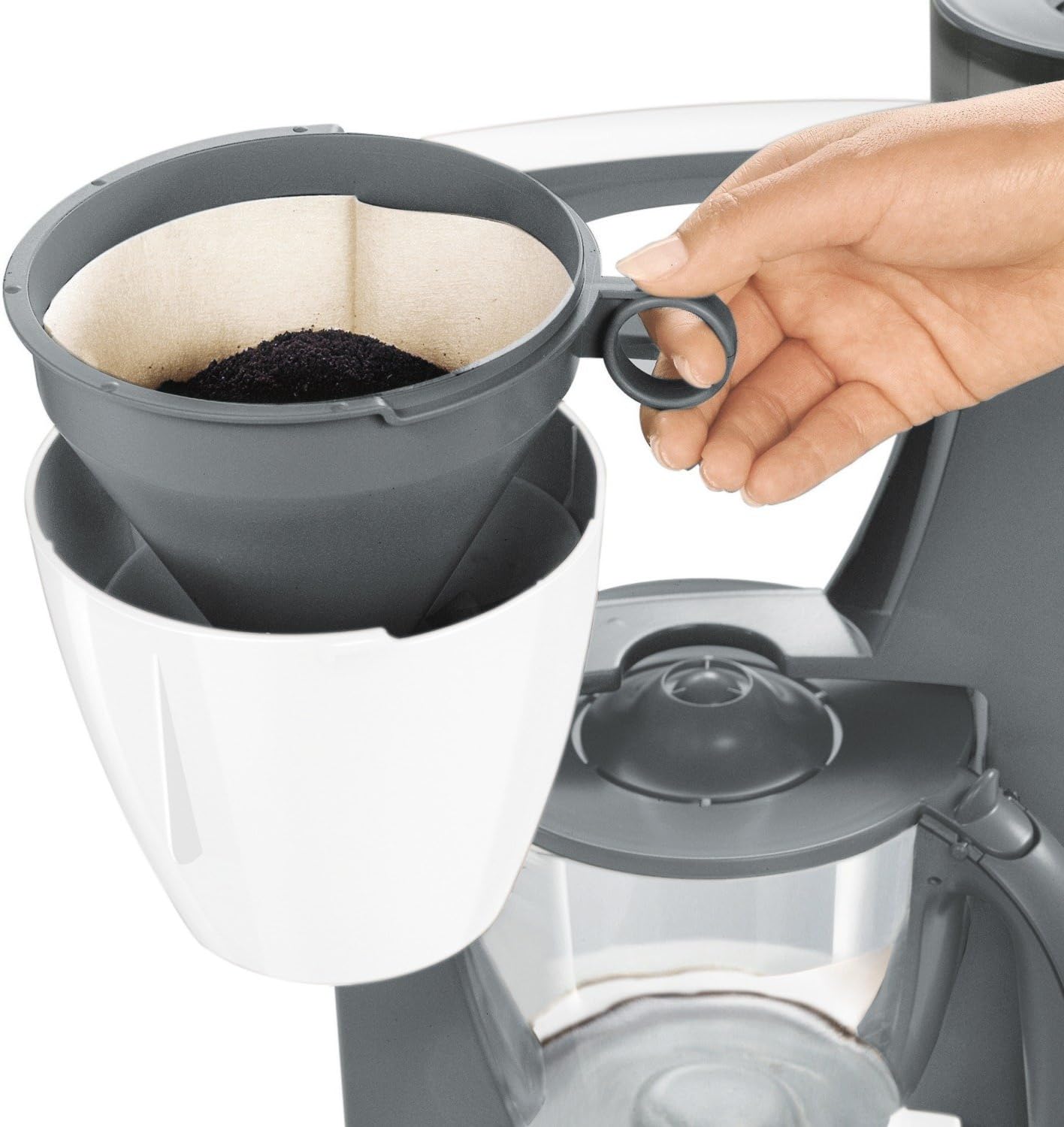 Hand placing coffee filter with grounds into the filter holder of the Bosch TKA6031A