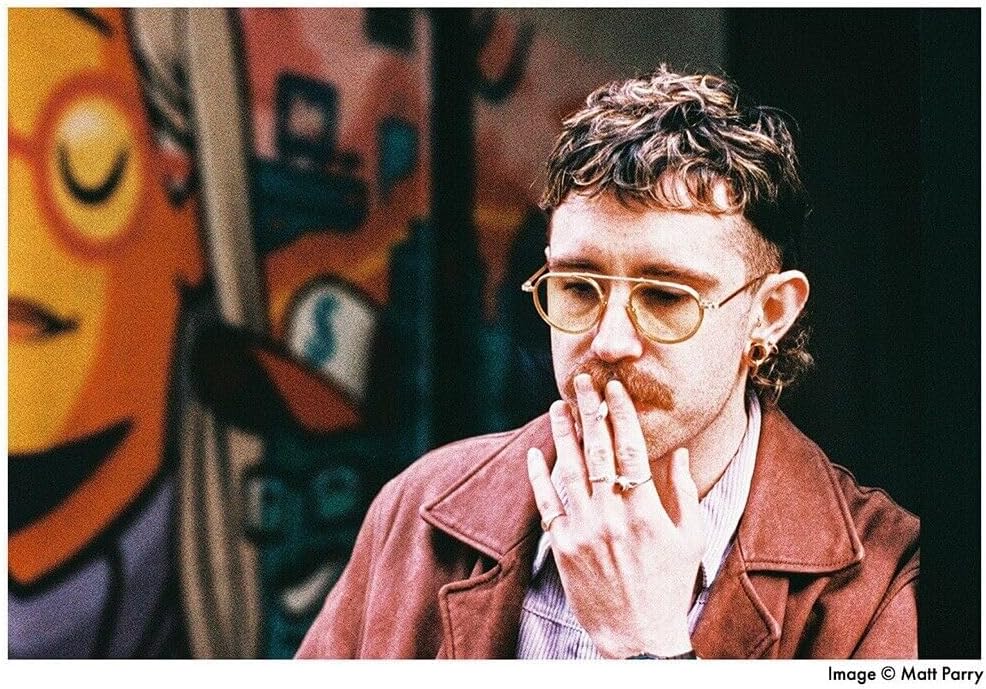 Sample photo taken with Harman Photo Phoenix 200 film, showing a person smoking with visible grain and color characteristics.