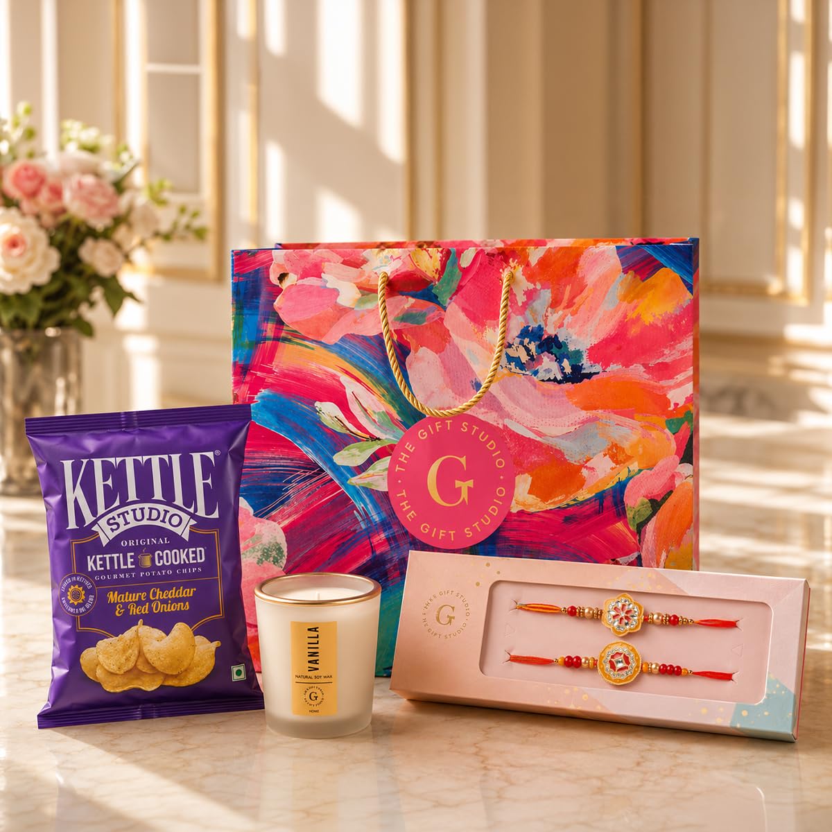 THE GIFT STUDIO.COM | Designer Bloom Gift Hamper for Brother | Set of 2 Enamel Rakhis, Vanilla Candle, Cheddar Chips & Floral Gift Bag | Raksha Bandhan Gift-image-1