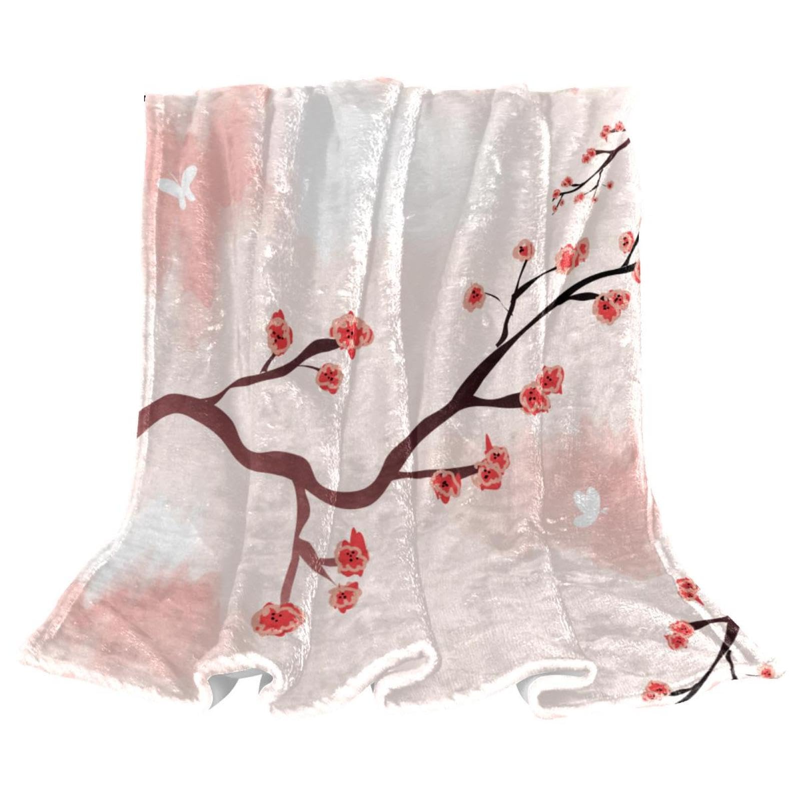 Plaid polaire rose motif fleur de prunier, couverture cocooning idéale sur le canapé