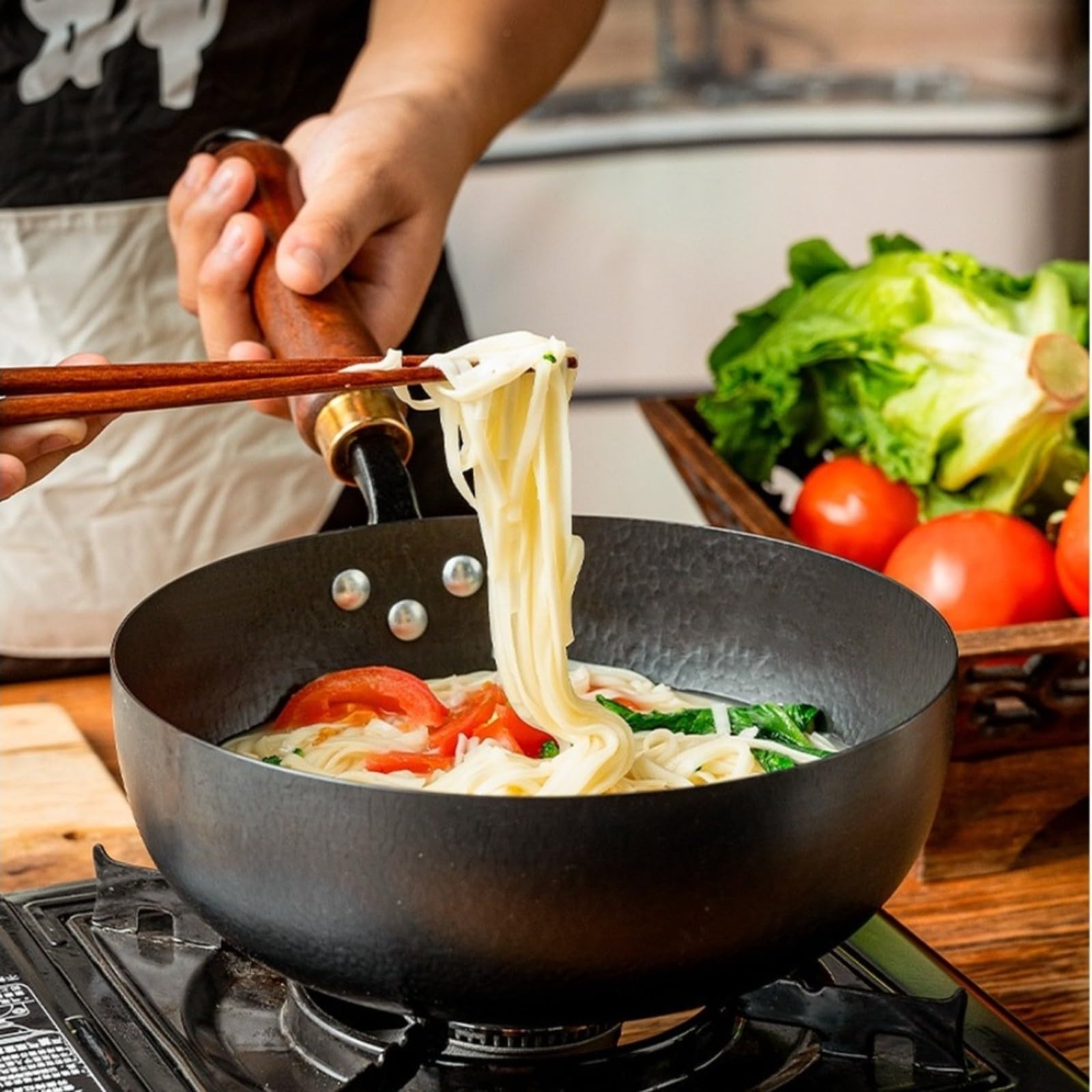 Hand-Hammered Cast Iron Wok 24 cm Wooden Handle | El compuesto de metal sólido se coloca en la zona de cocción, distribuye el calor de manera uniforme y facilita la cocción.