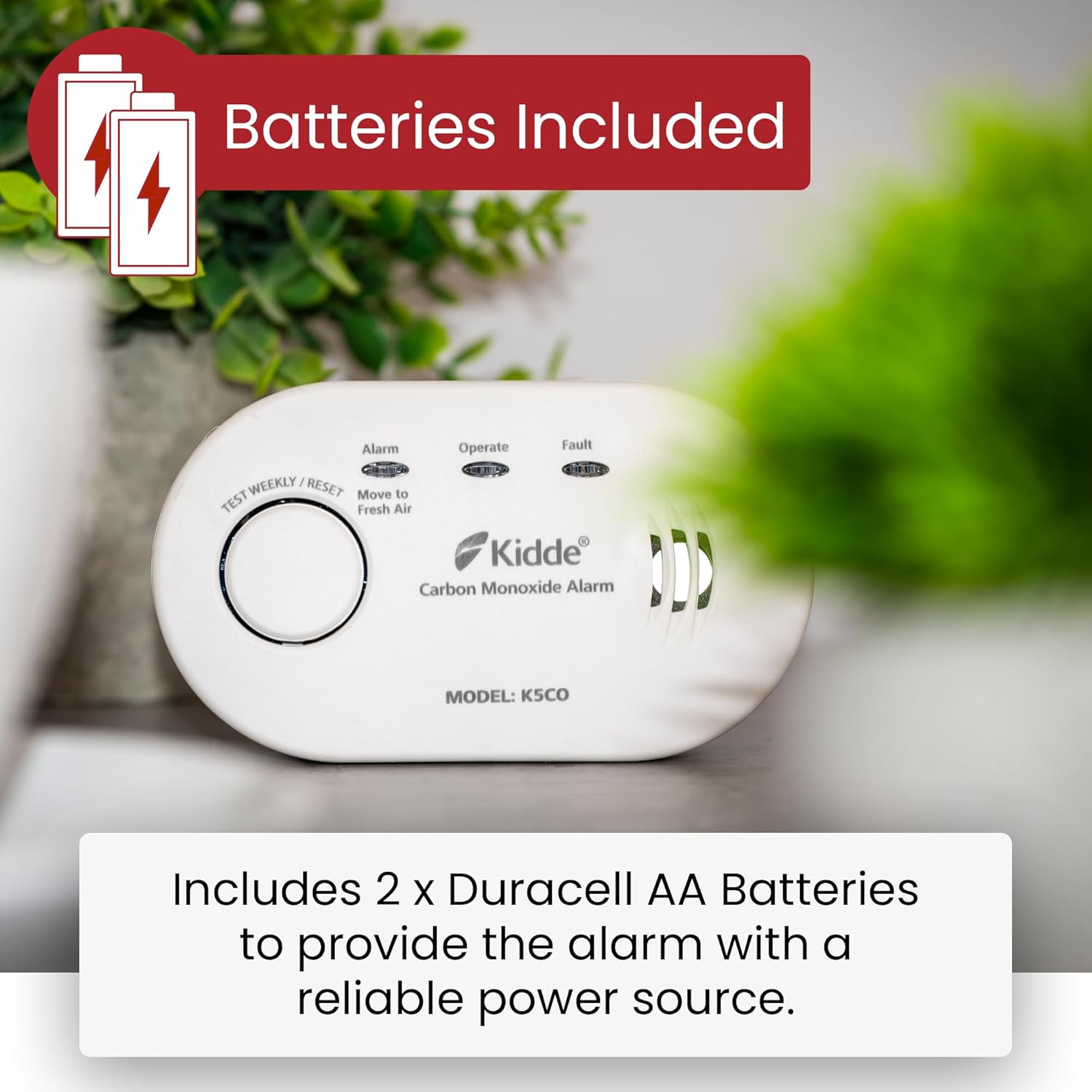 Kidde 5CO Carbon Monoxide Alarm on a wooden surface with text 'Batteries Included' and 'Includes 2 x Duracell AA Batteries to provide the alarm with a reliable power source'.