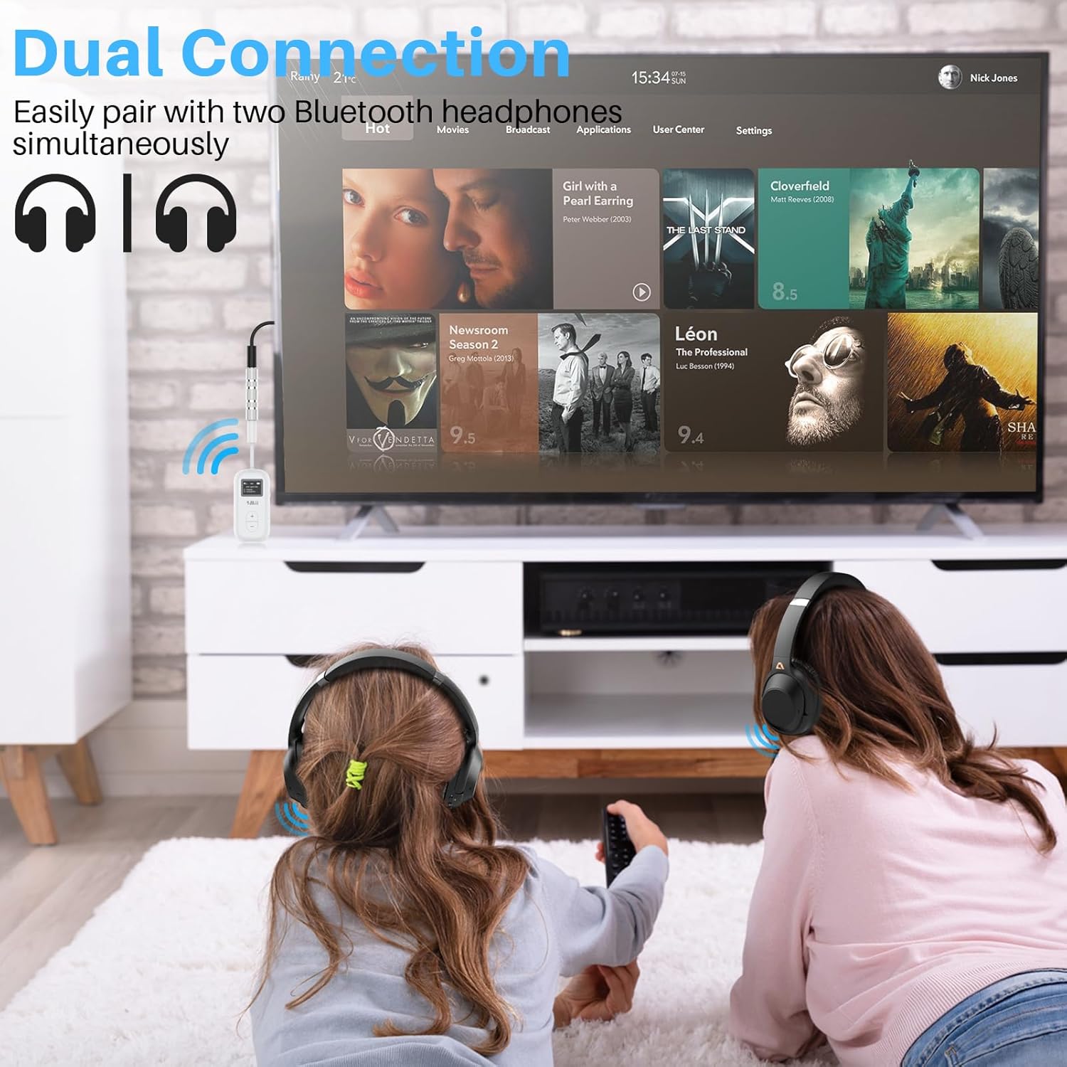 Two children wearing Bluetooth headphones connected to a 1Mii SafeFly Dual transmitter plugged into a TV