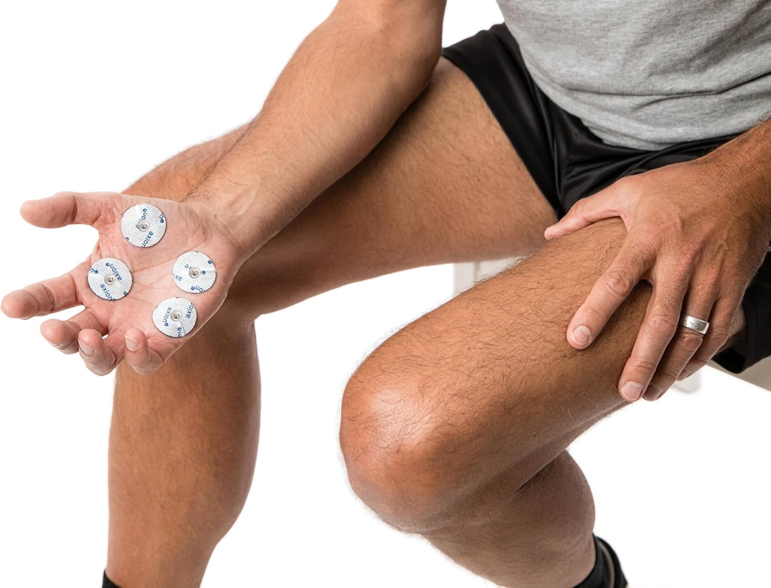 Small round electrodes held in a person's hand, demonstrating their size.