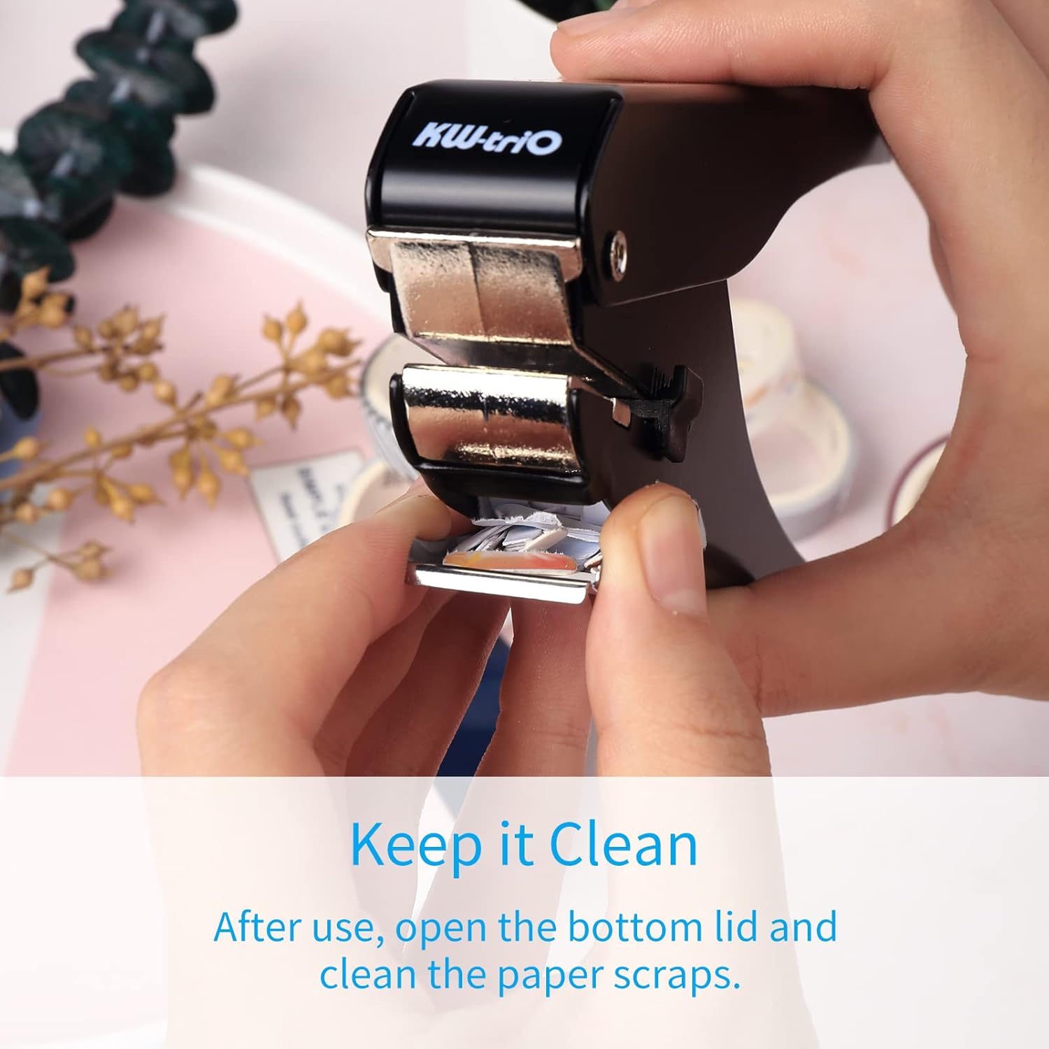 Instructions for cleaning the KW-triO slot punch by opening the bottom lid to remove paper scraps