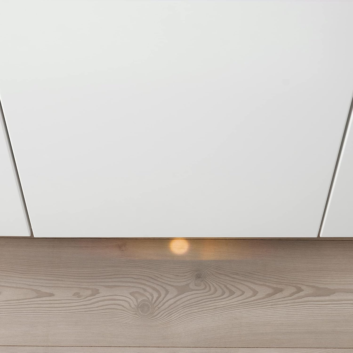 Orange light projected onto the floor from an integrated dishwasher