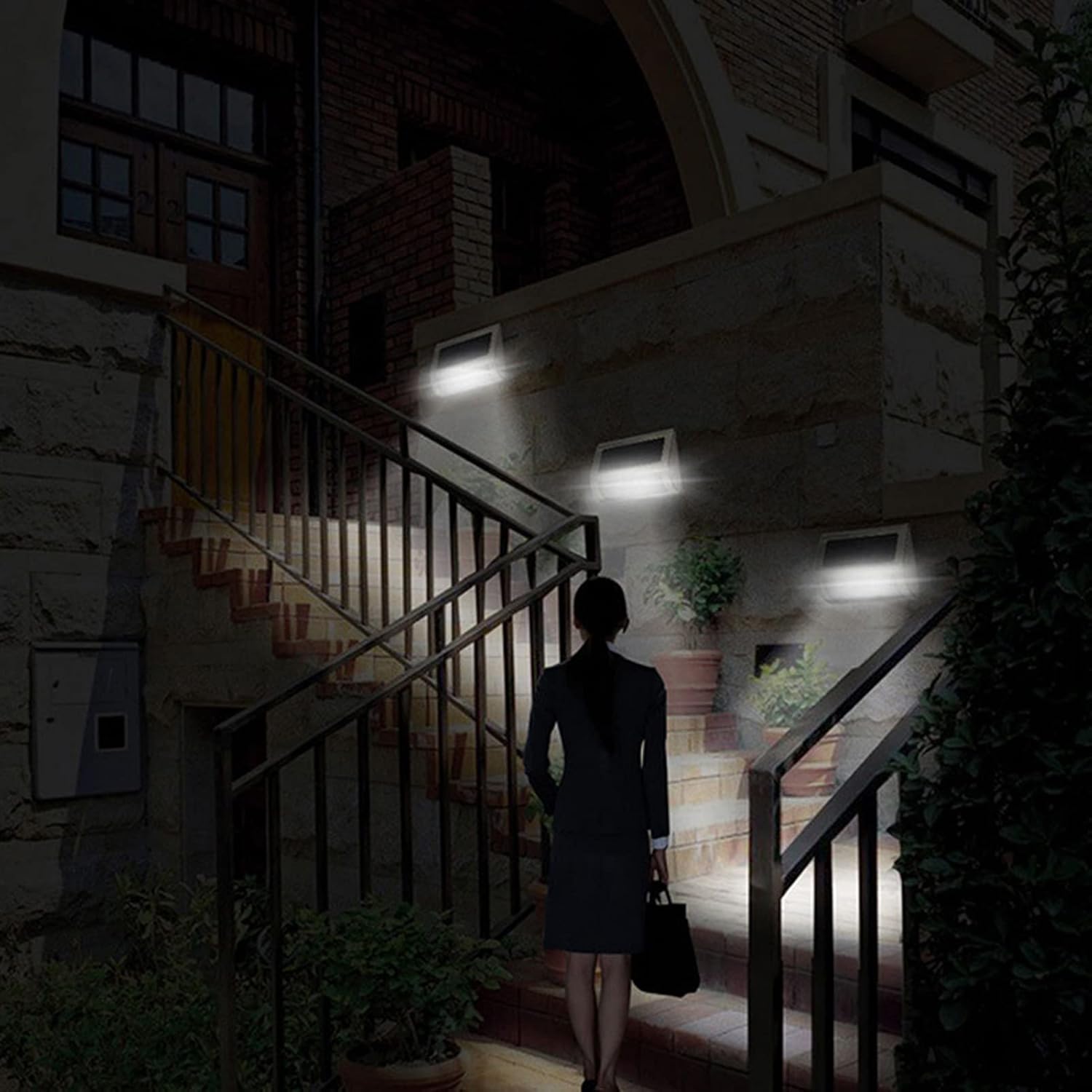 Solar flood lights illuminating outdoor stairs at night with a person walking