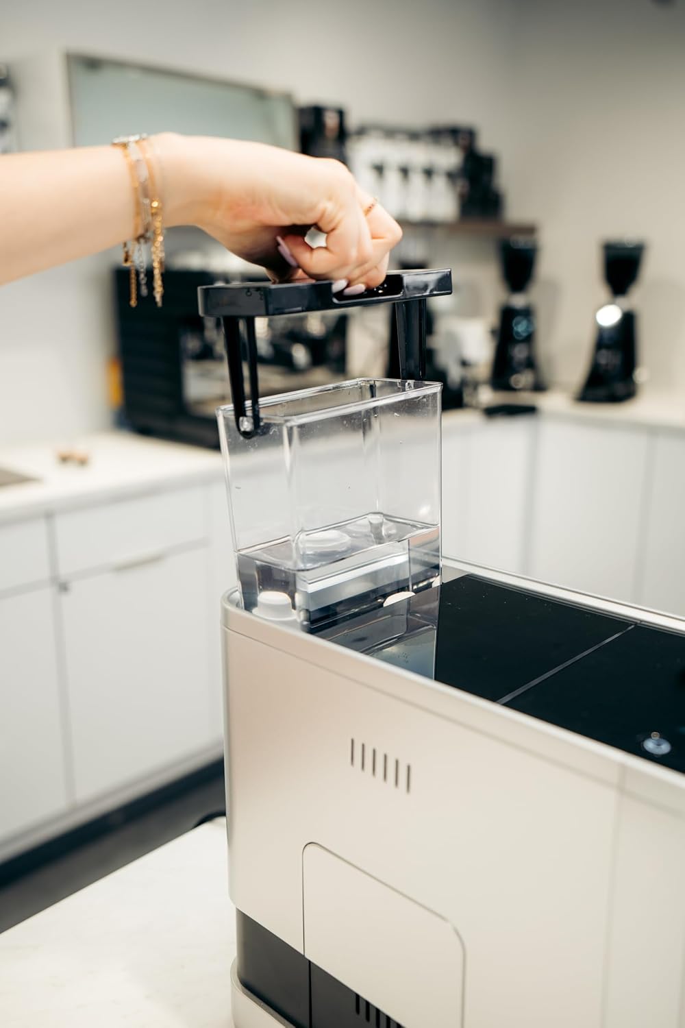 Hand removing the water tank from the Bellucci Slim Caffè espresso machine