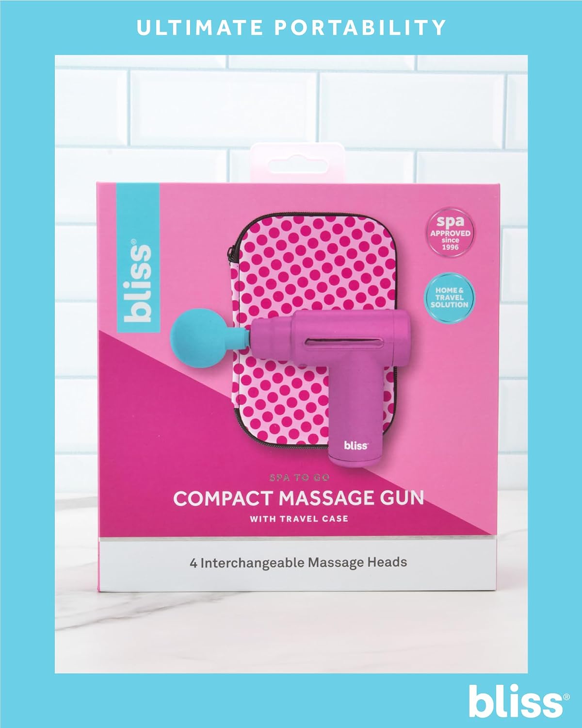 Bliss Massage Gun packaging showing the pink massage gun, four massage heads, and travel case.