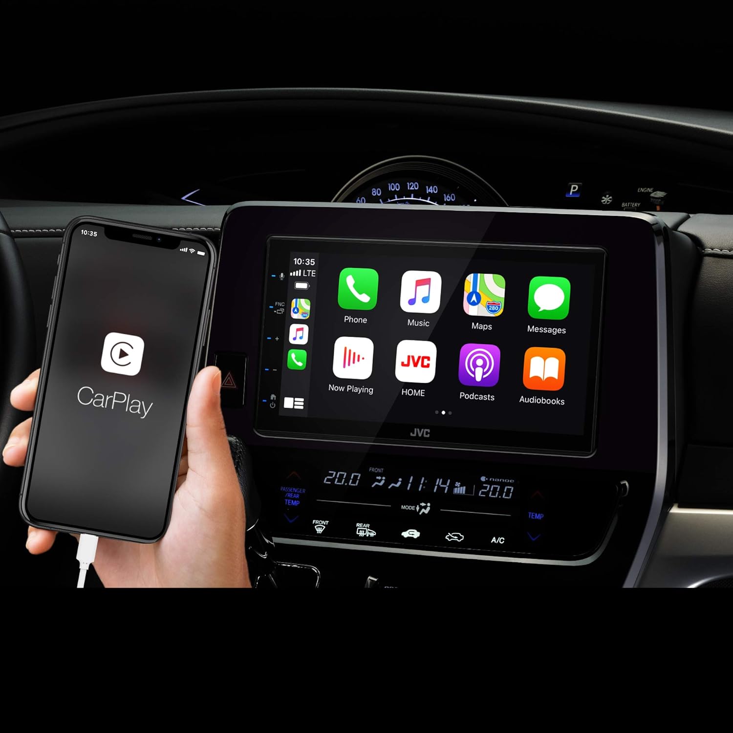 User holding an iPhone connected to the JVC KW-M565DBT displaying Apple CarPlay apps.