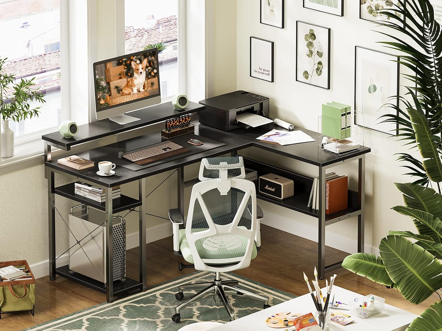 An ODK L-shaped desk set up in a home office with a monitor on the stand, a printer, and various office items.
