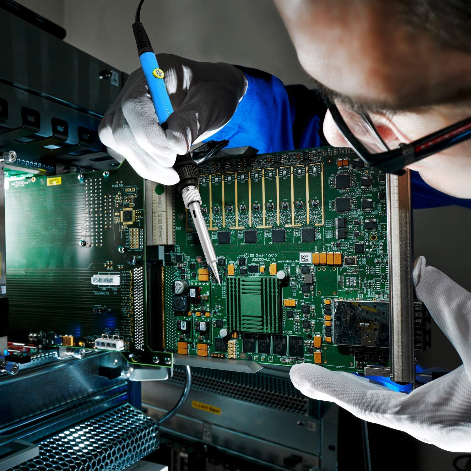 Person soldering a circuit board with the SREMTCH iron