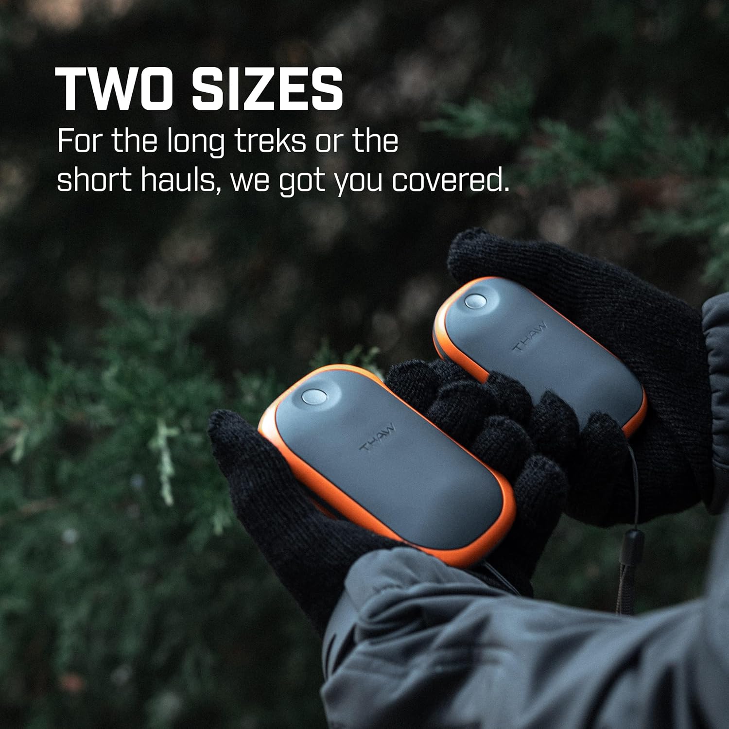 Two THAW hand warmers, small and large, held by gloved hands outdoors.