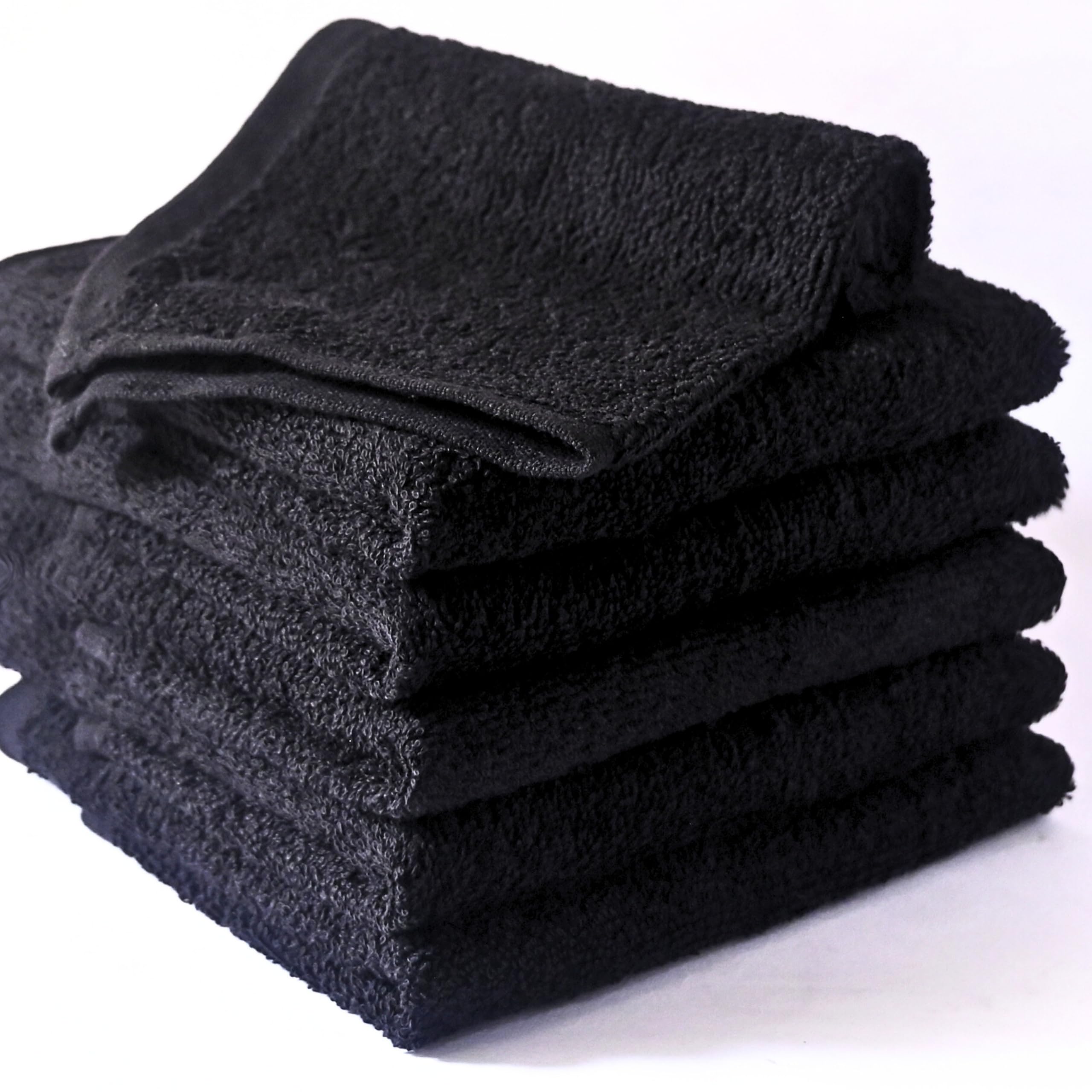 A stack of soft, black 100% cotton washcloths, ready for use in the bathroom.