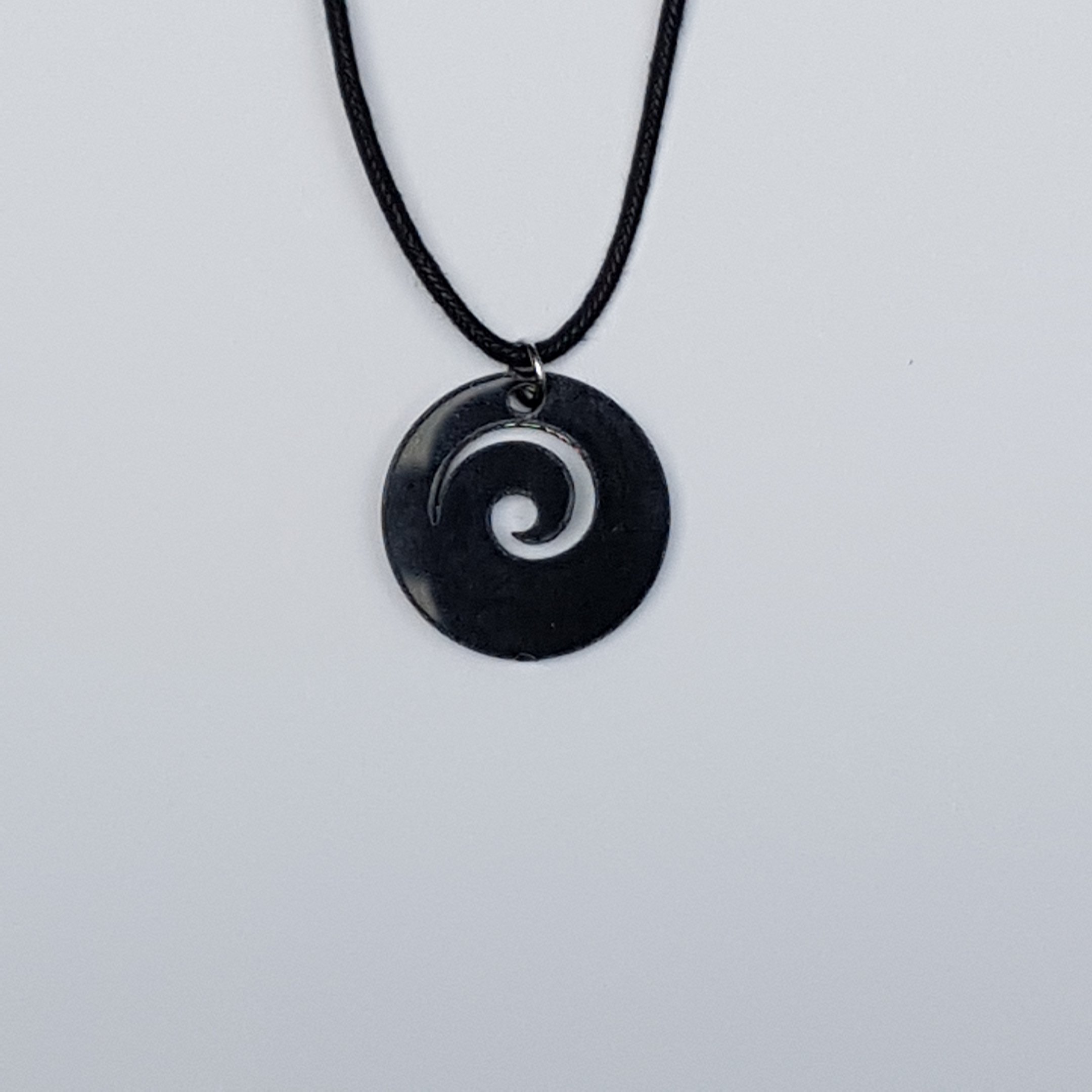 Collier à pendentif Maori Koru ou Wave Crest - Incrustation d'ormeau paua bleuté et vert sur disque en plastique noir - Avec cordon noir de 45,7 cm