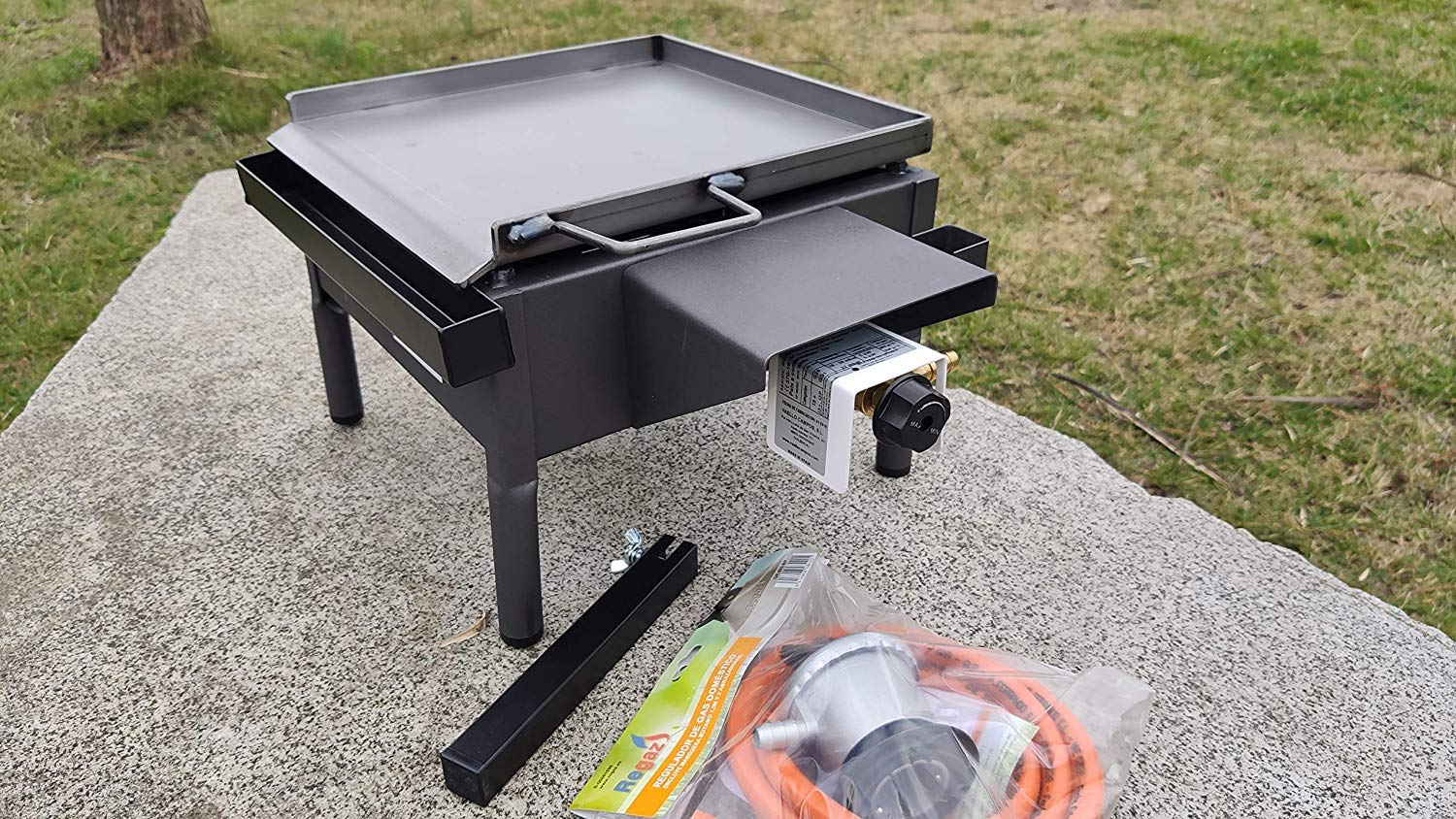 Barbacoa de Gas Portátil con Plancha Plegable de Acero Pulido | Asador de Sobremesa con Patas ideal para el Jardín de Casa | Incluye Paellero Vitrificado de 20cm + Regulador + Manguera 31x32x24cm