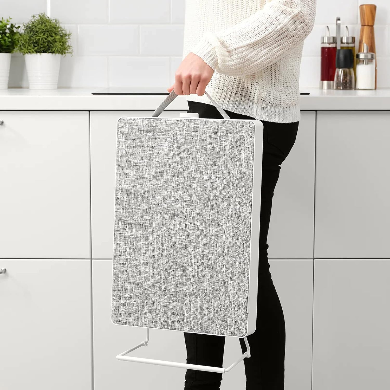 Person carrying Ikea FÖRNUFTIG Air Purifier by handle